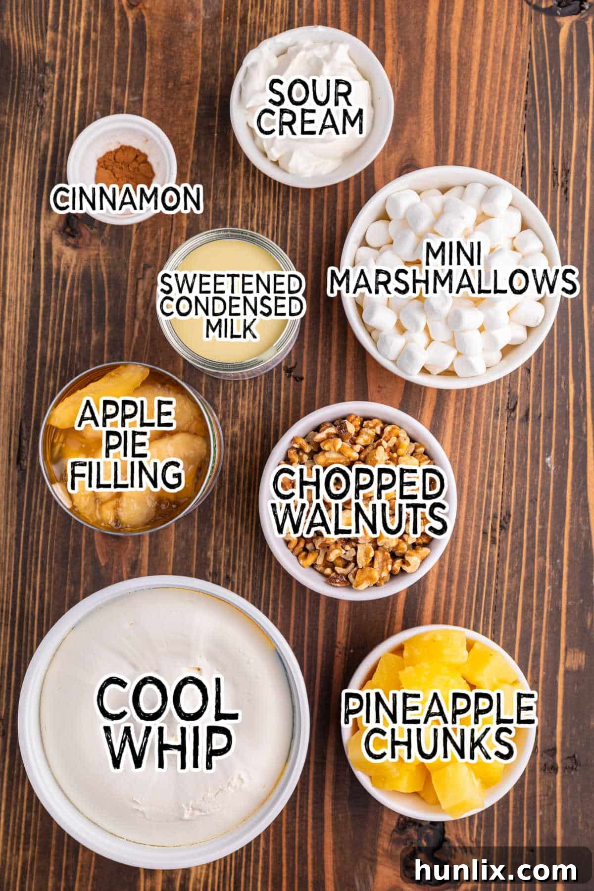 Various ingredients for Apple Pie Fluff arranged on a table, including canned apple pie filling, marshmallows, and Cool Whip.