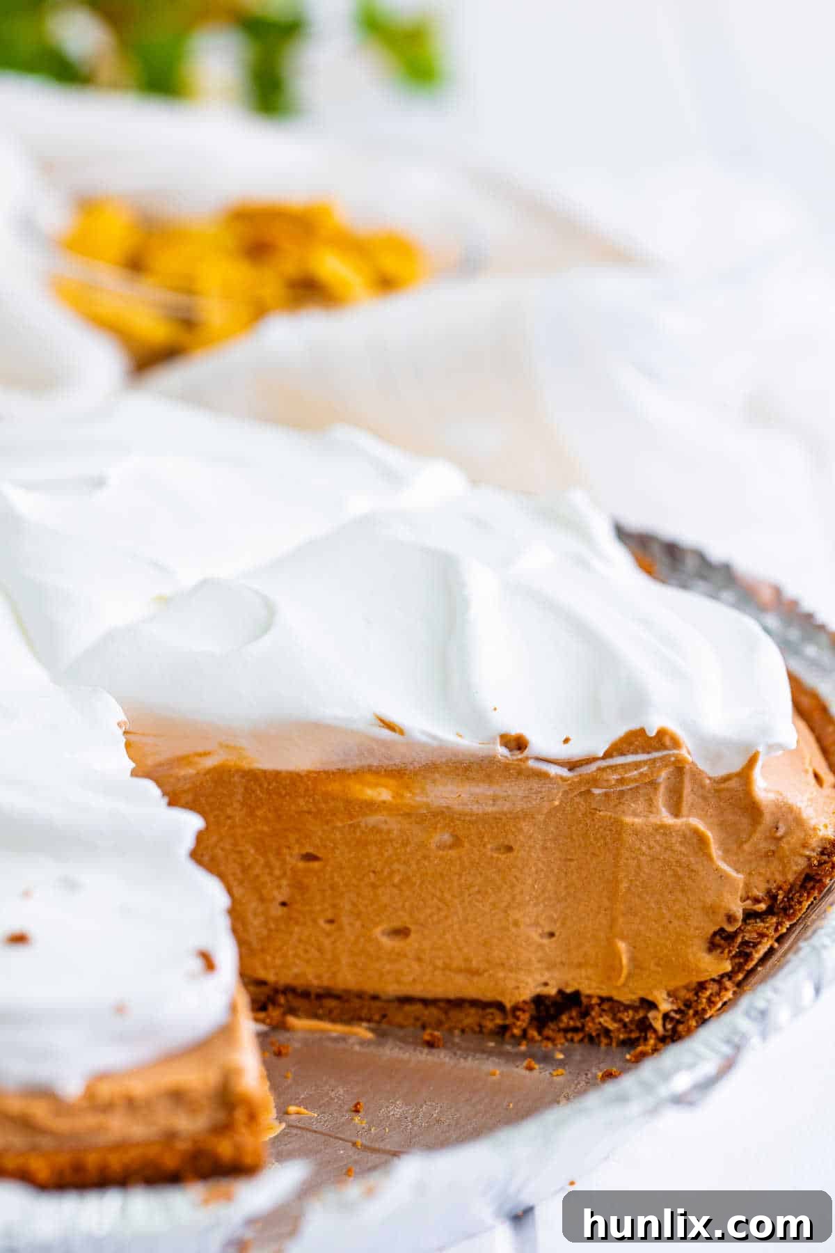 Heavenly Chocolate Peanut Butter Indulgence 2 A delectable slice of no-bake chocolate peanut butter pie with a golden spoon, showcasing its creamy layers and chocolate crust.