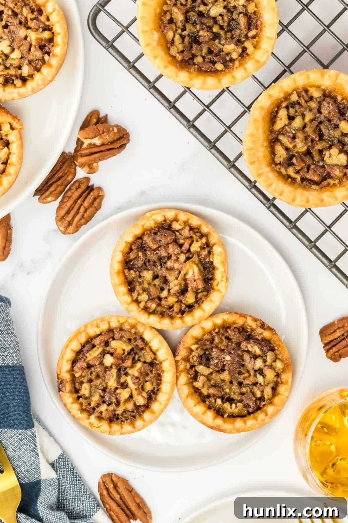 Decadent Bourbon Pecan Tarts 2 Pecan bourbon butter tarts on a plate.