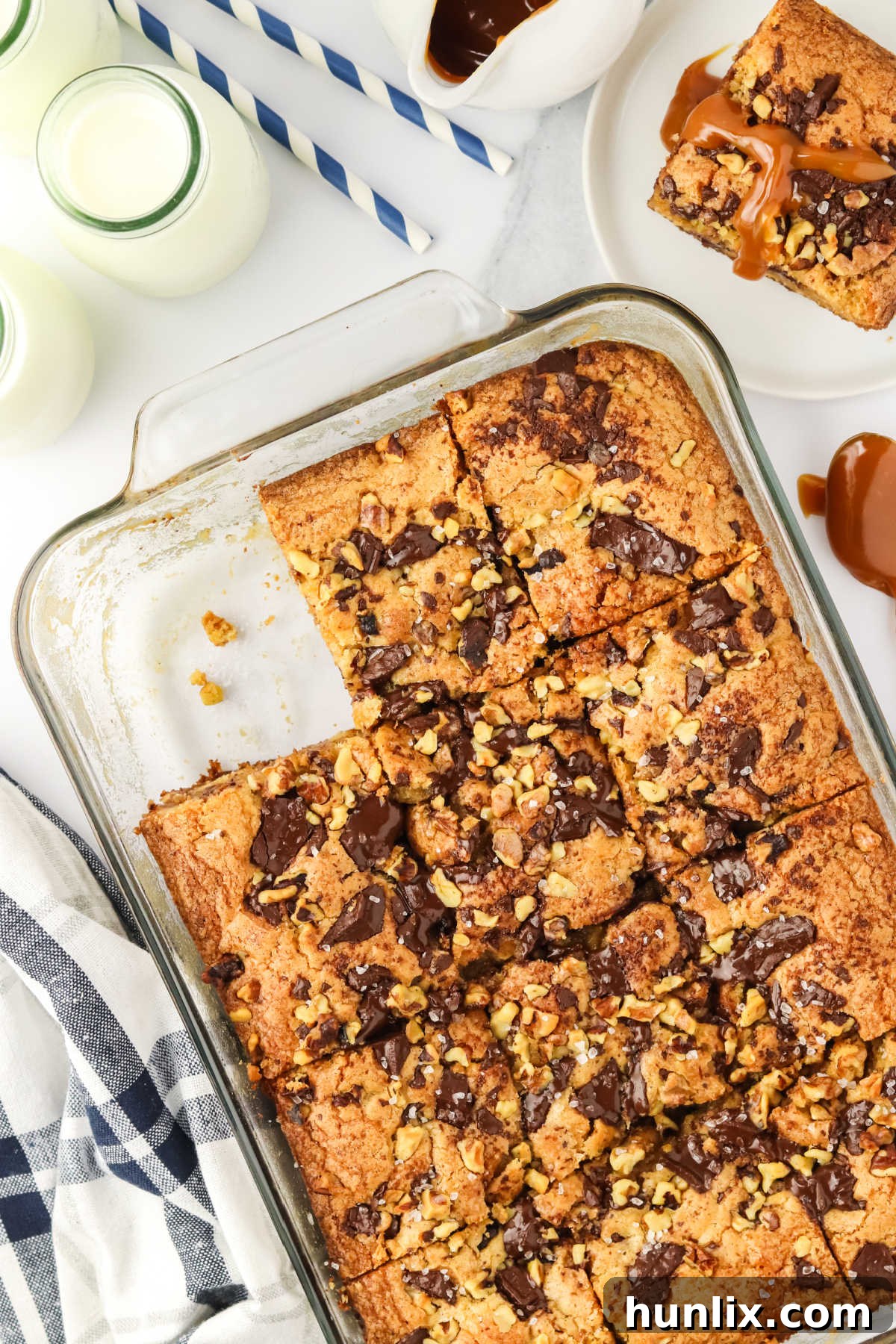 Brown butter caramel blondies artfully arranged in a baking pan, showcasing their golden-brown edges and gooey caramel swirls.