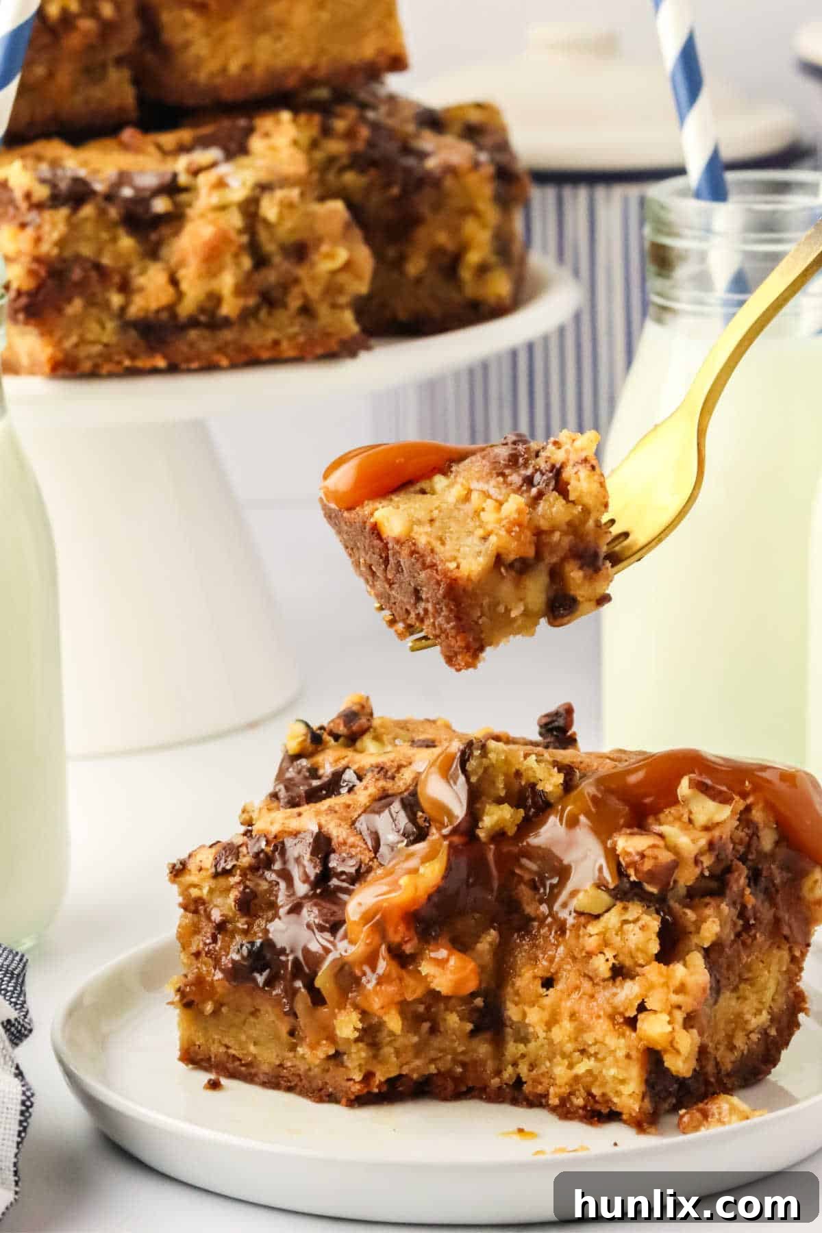 A fork holding a piece of brown butter caramel blondie, highlighting its chewy texture and gooey center.