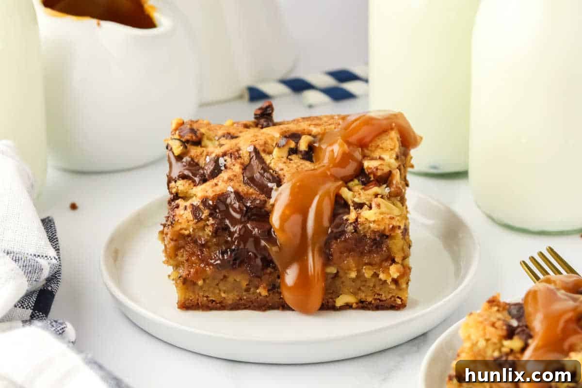 A slice of brown butter caramel blondie on a white plate, showcasing its gooey center and golden exterior.