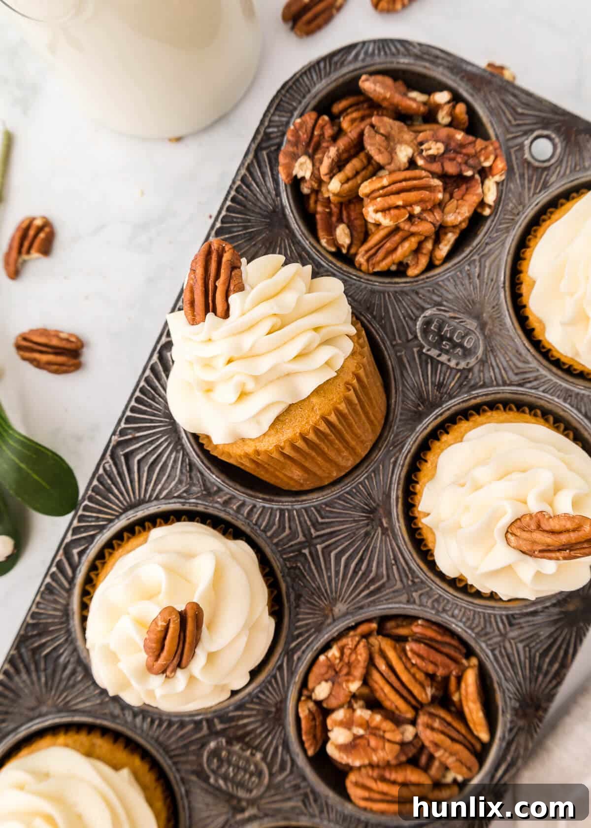 Pecan pie cupcakes in a muffin pan, showcasing their golden tops and festive appeal.