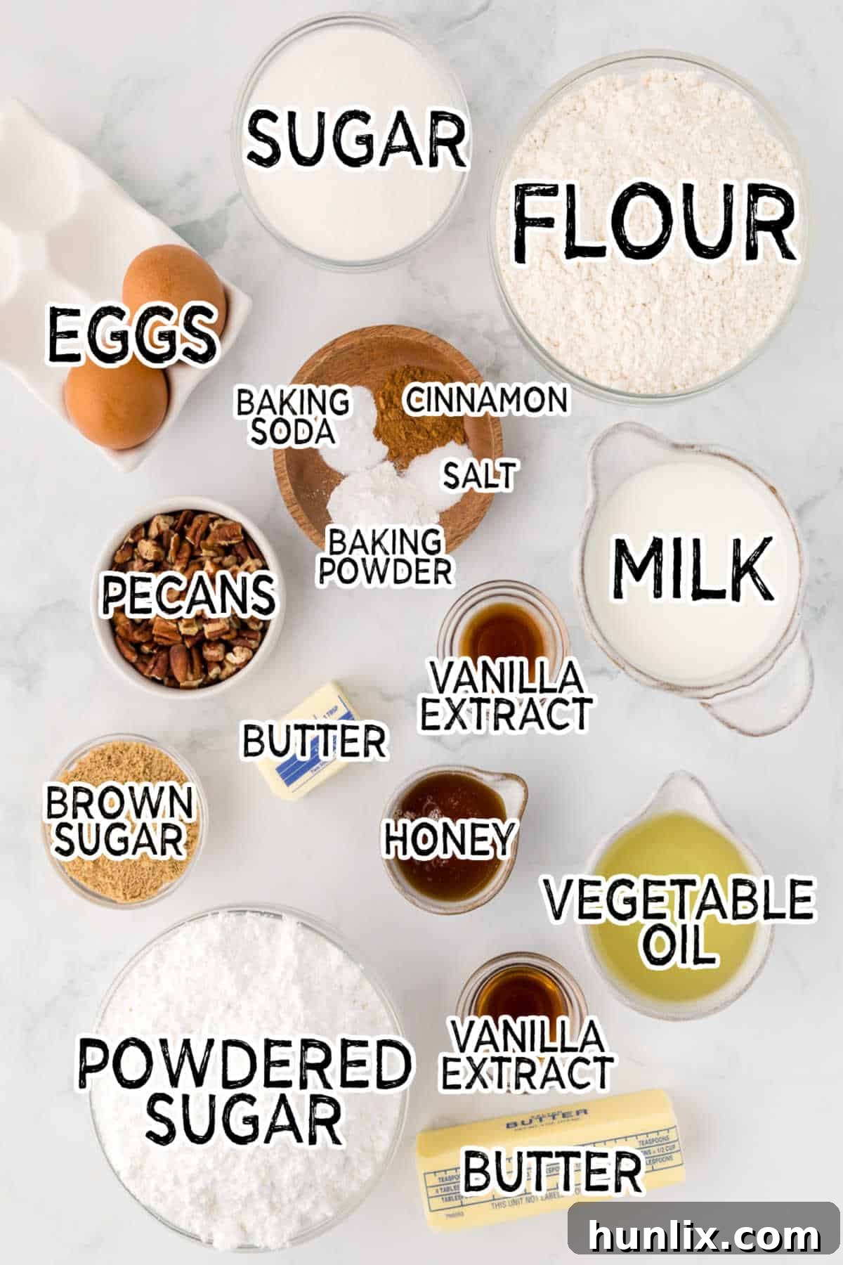 Assortment of baking ingredients on a marble counter, ready for pecan pie cupcakes.