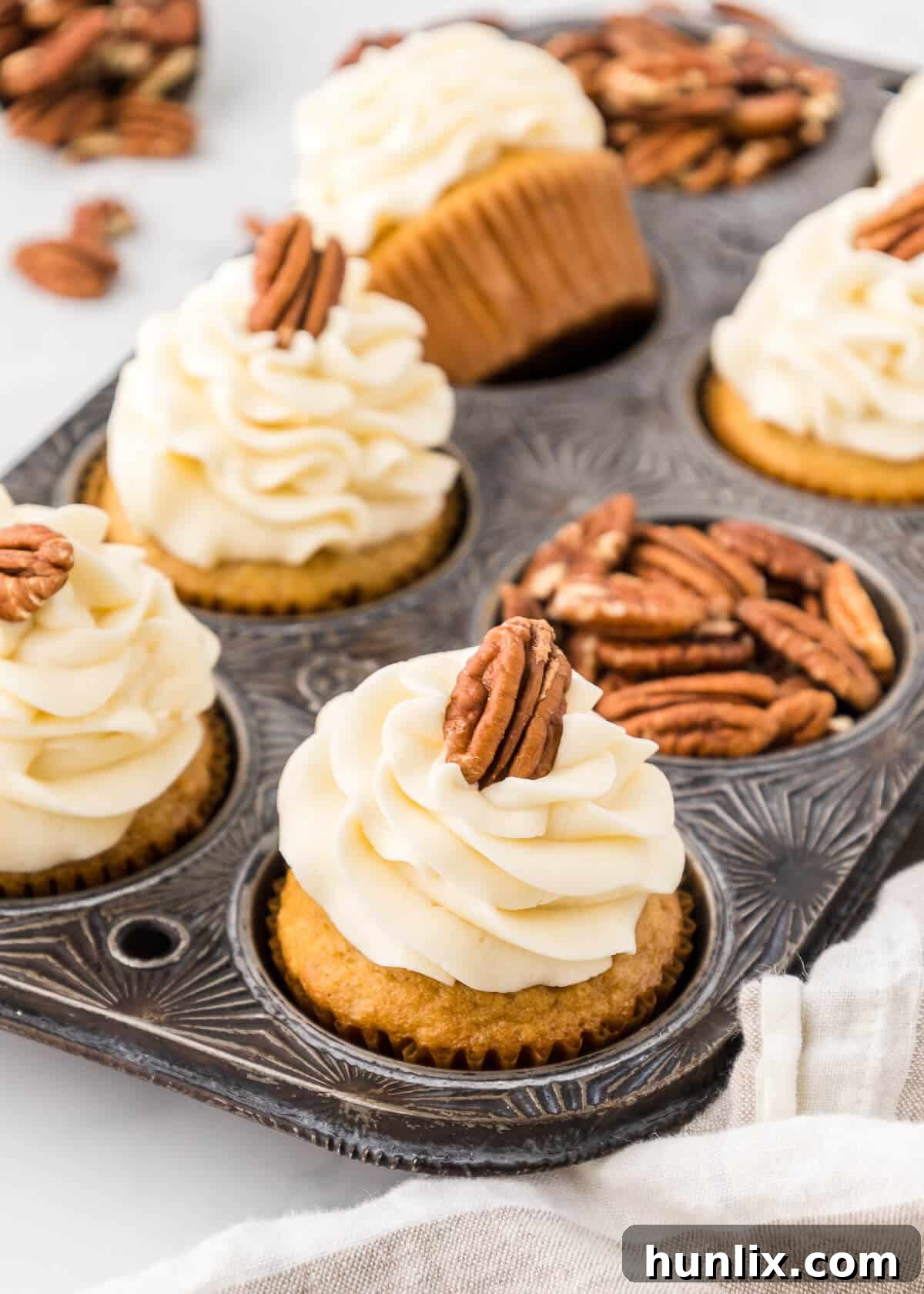 Finished pecan pie cupcakes arranged appealingly in a muffin tin.