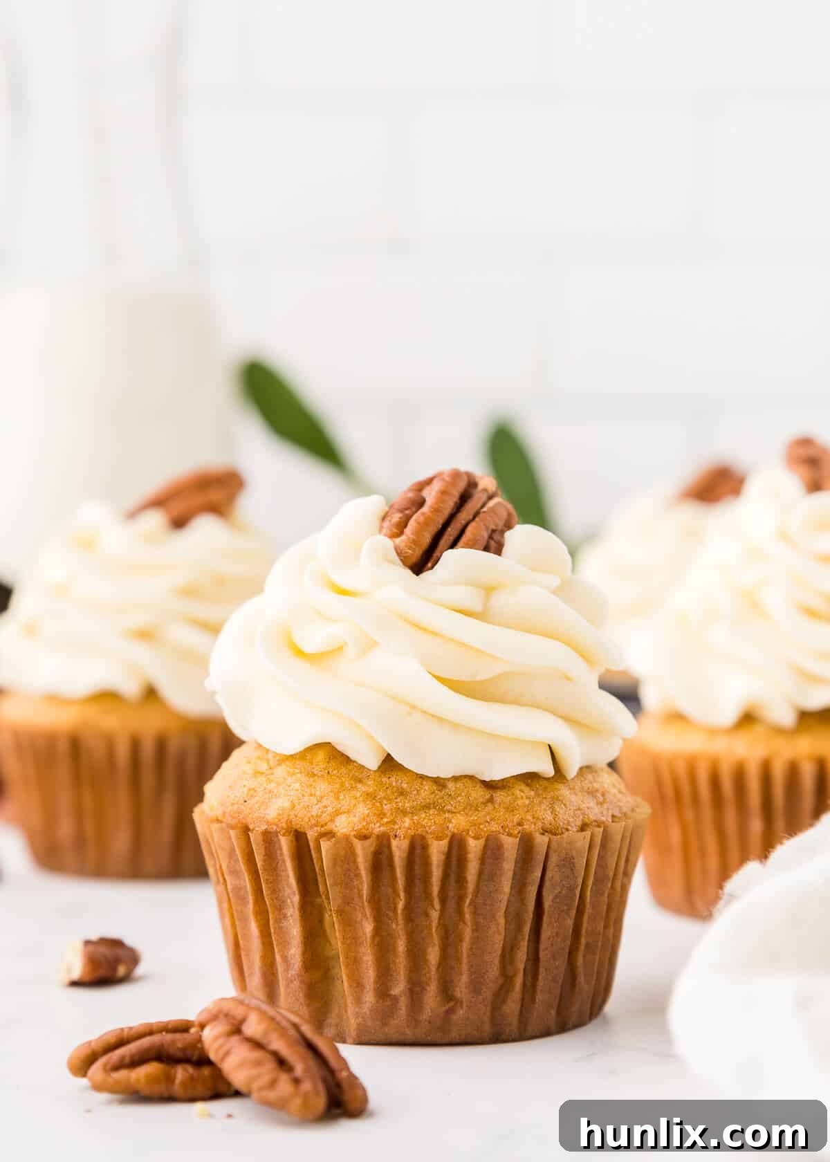 Several pecan pie cupcakes neatly arranged on a pristine white surface.