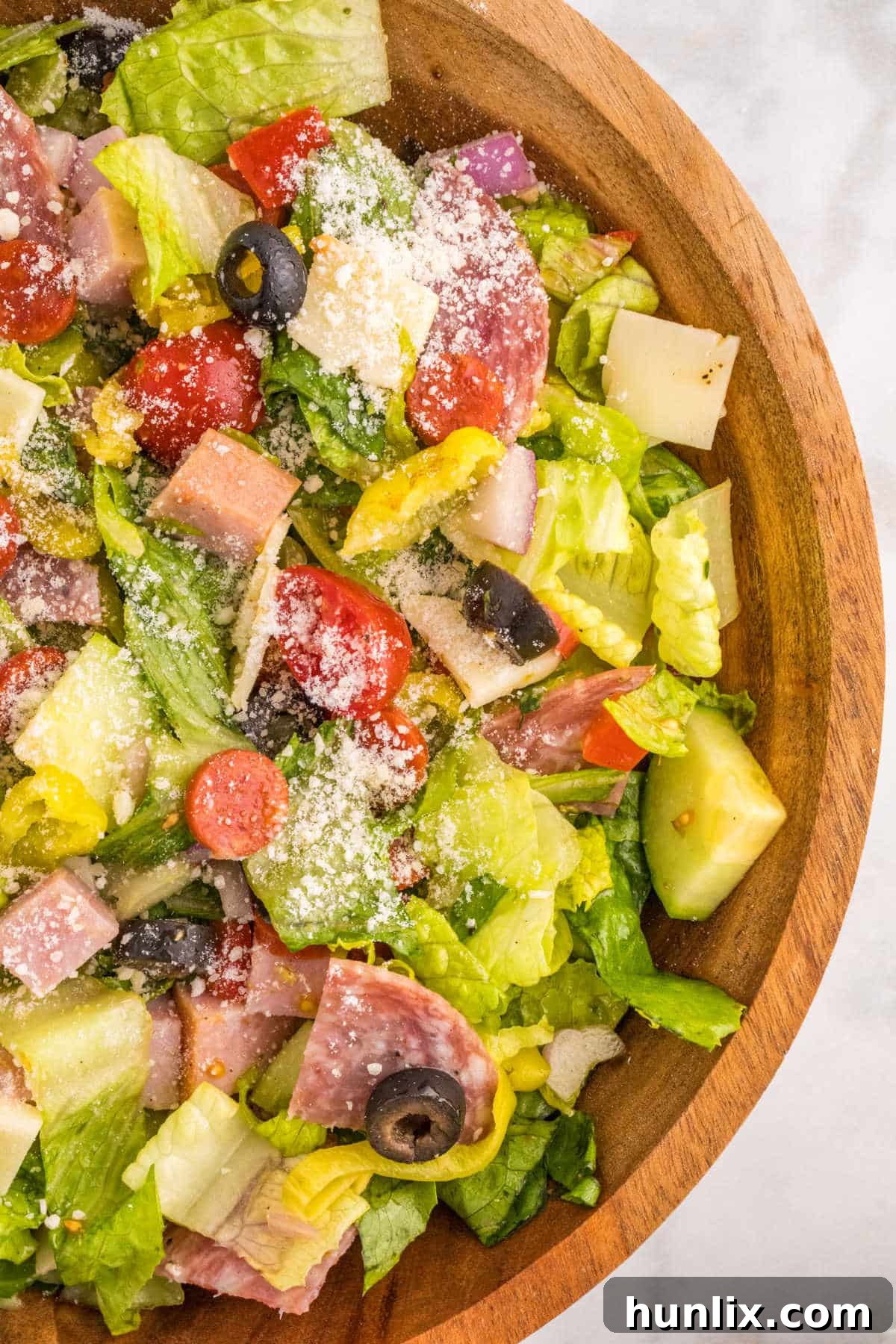 Italian sub salad in a wooden bowl, showcasing vibrant ingredients.