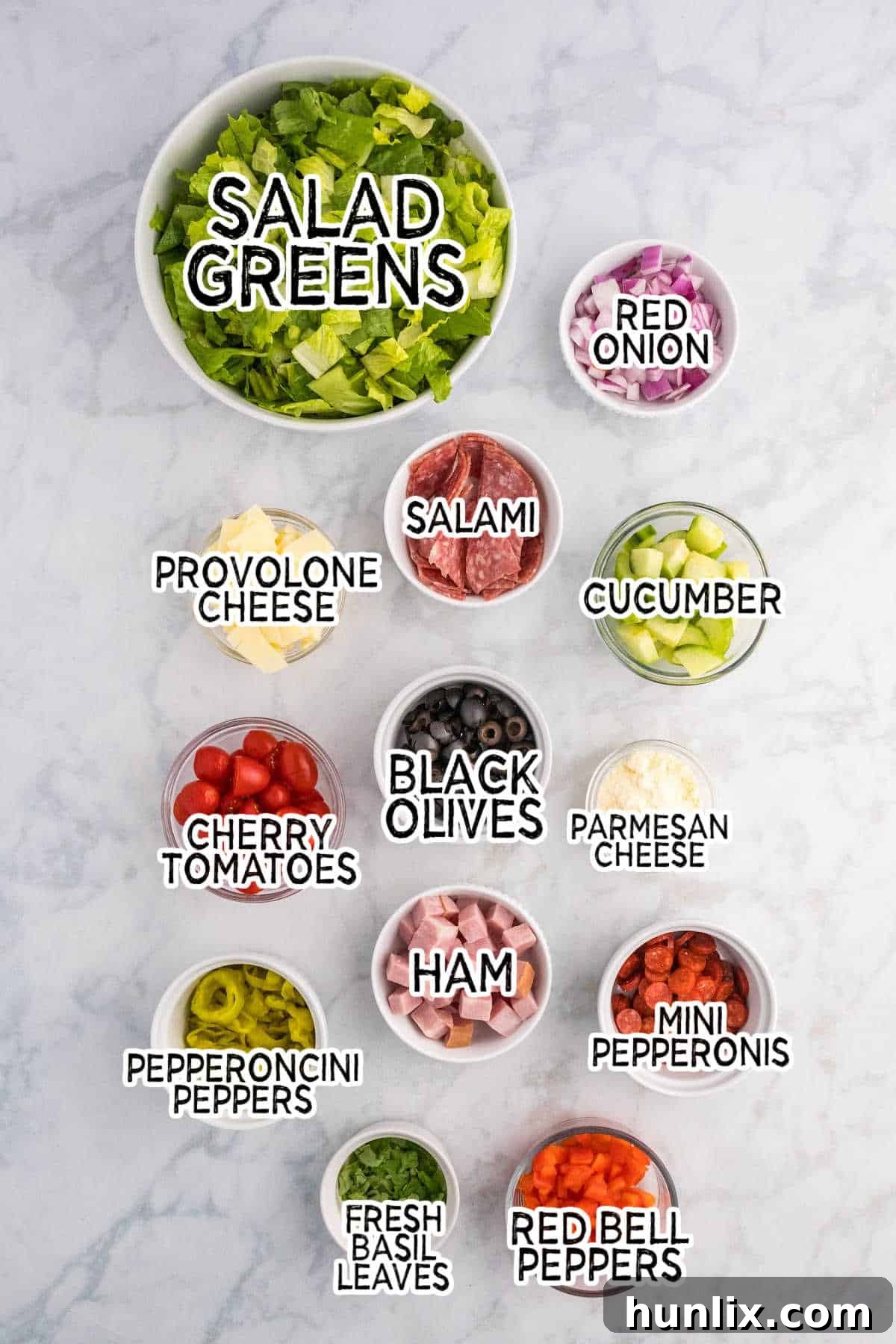 Assorted fresh ingredients laid out for Italian Sub Salad.