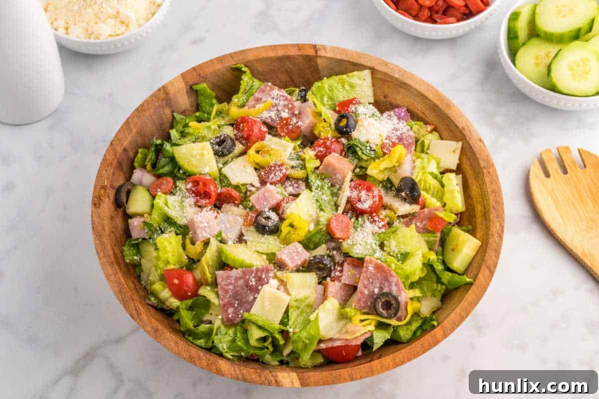 A beautifully presented Italian sub salad in a large wooden bowl.