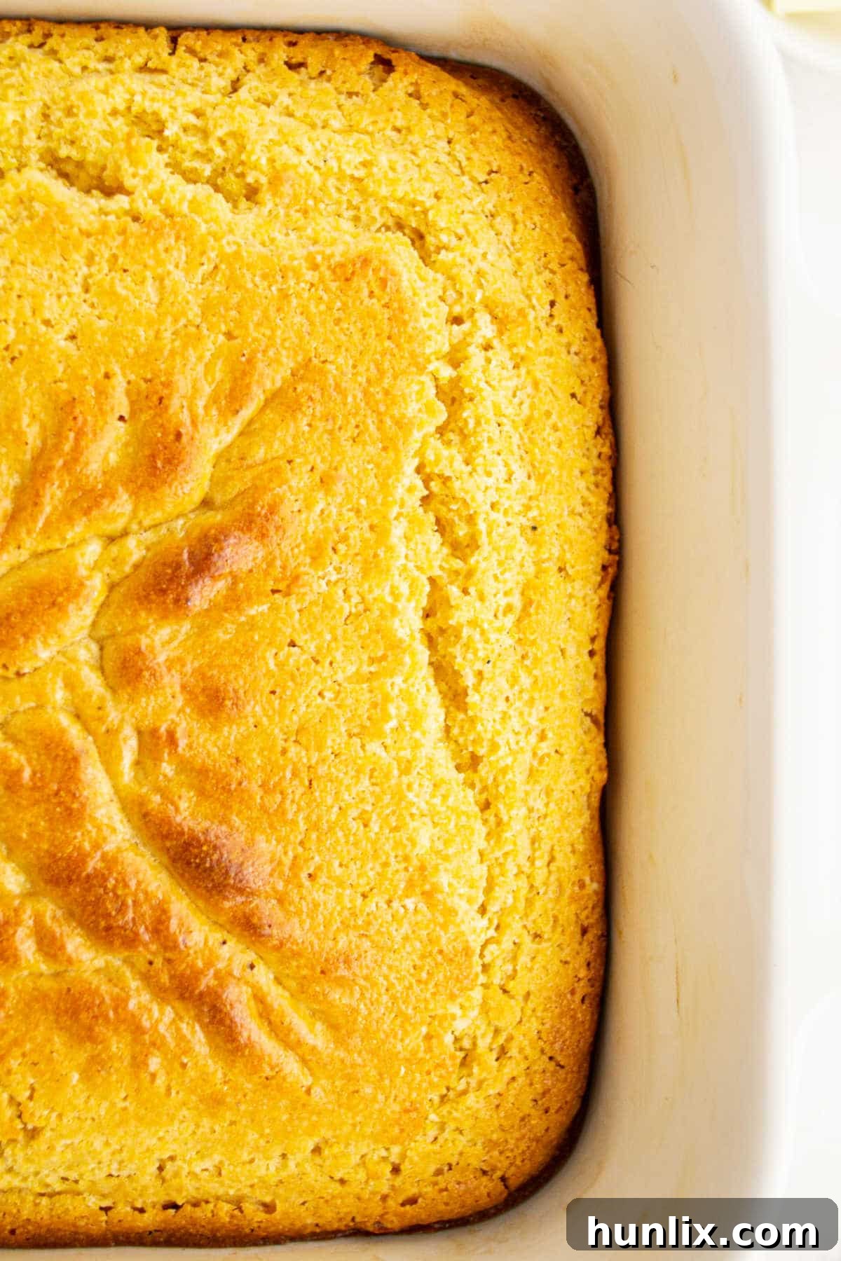 A perfectly baked Southern Corn Cake in a pan, golden brown and ready to serve.