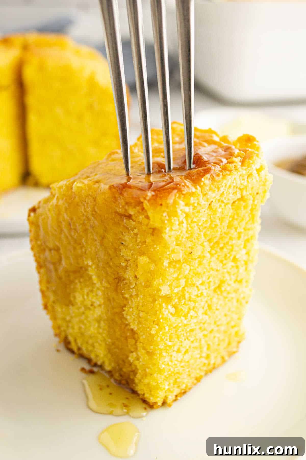 A piece of Southern Corn Cake with a fork ready to be eaten.