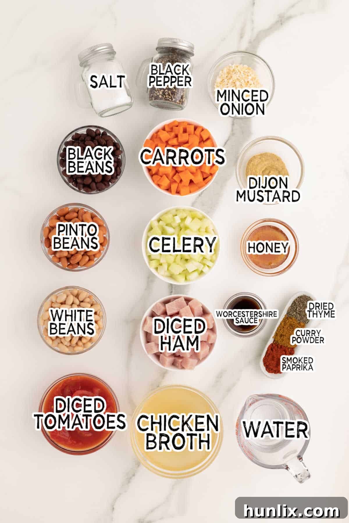 Ingredients laid out to make Crockpot Ham and Bean Soup, including various beans, vegetables, and spices.