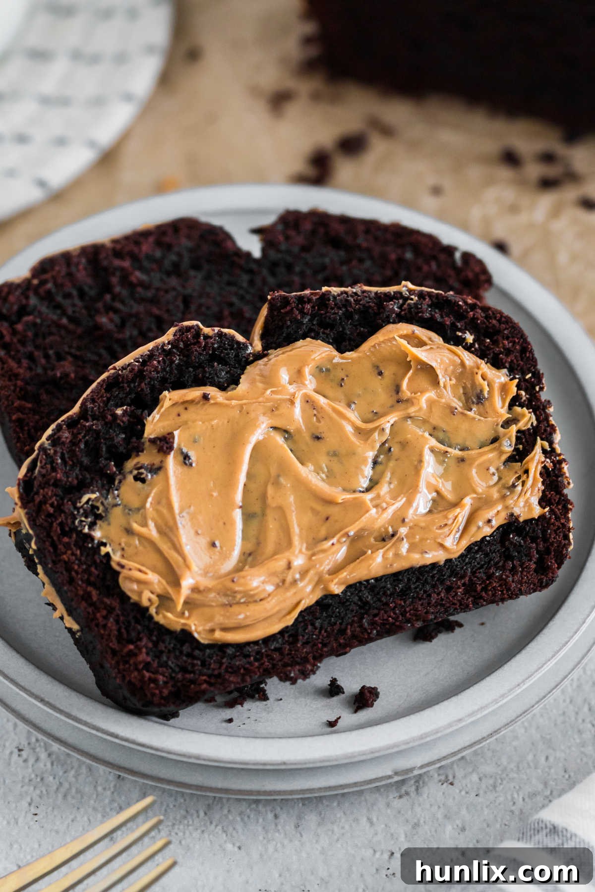 A slice of chocolate peanut butter banana bread with peanut butter.