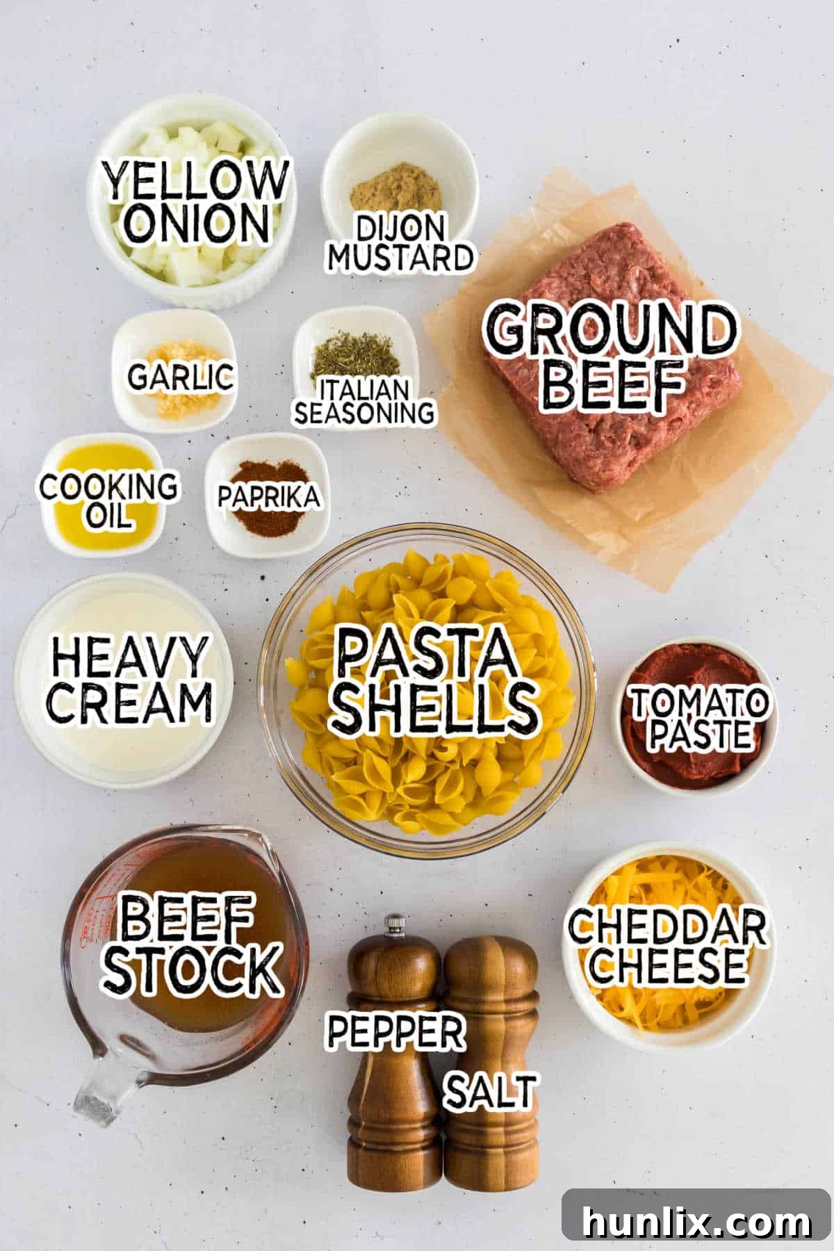 All the fresh ingredients laid out on a wooden board, ready to make creamy beef and shells.