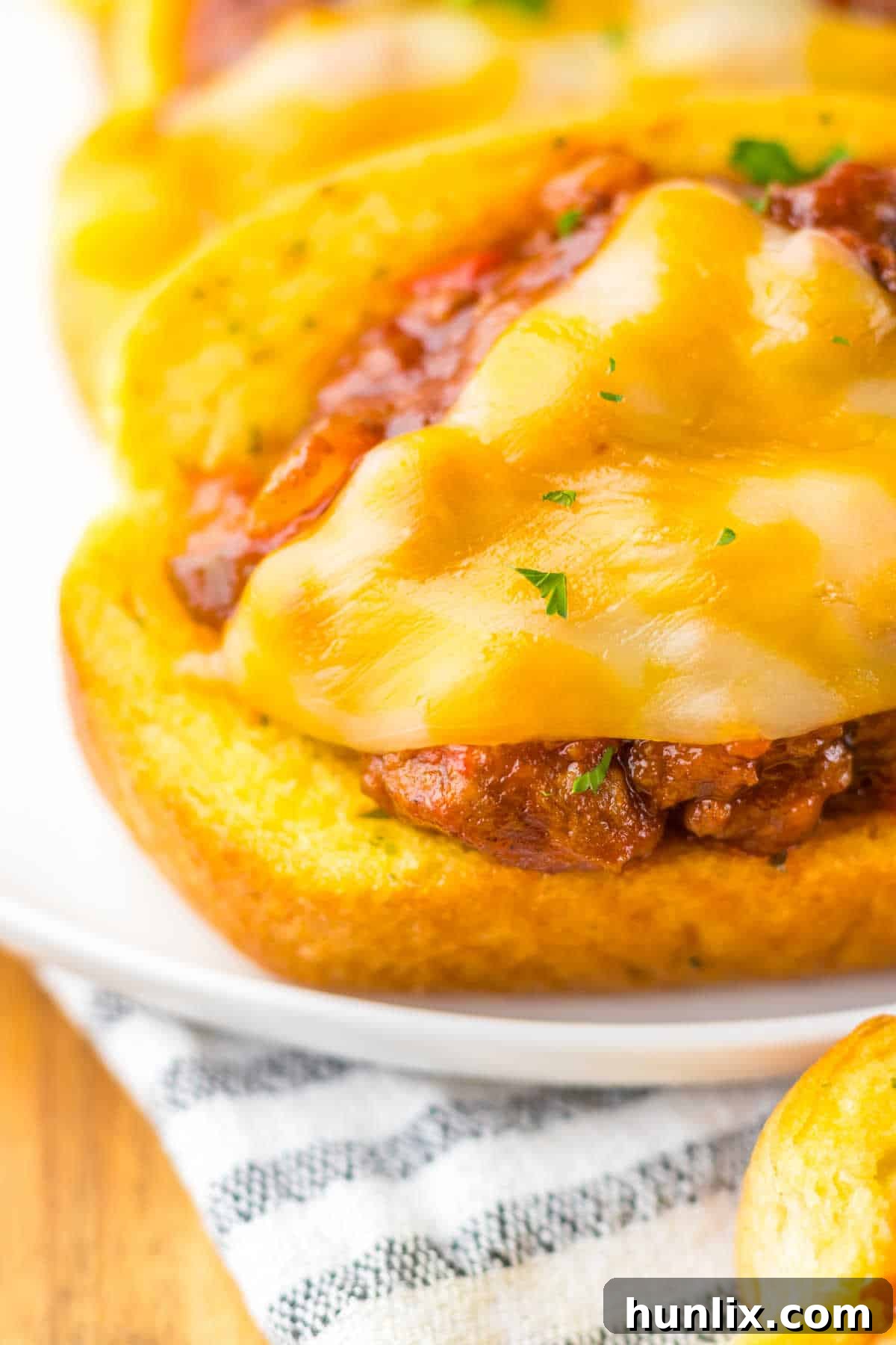 A single Texas Toast sloppy joe on a plate, showcasing the melted cheese and rich filling.