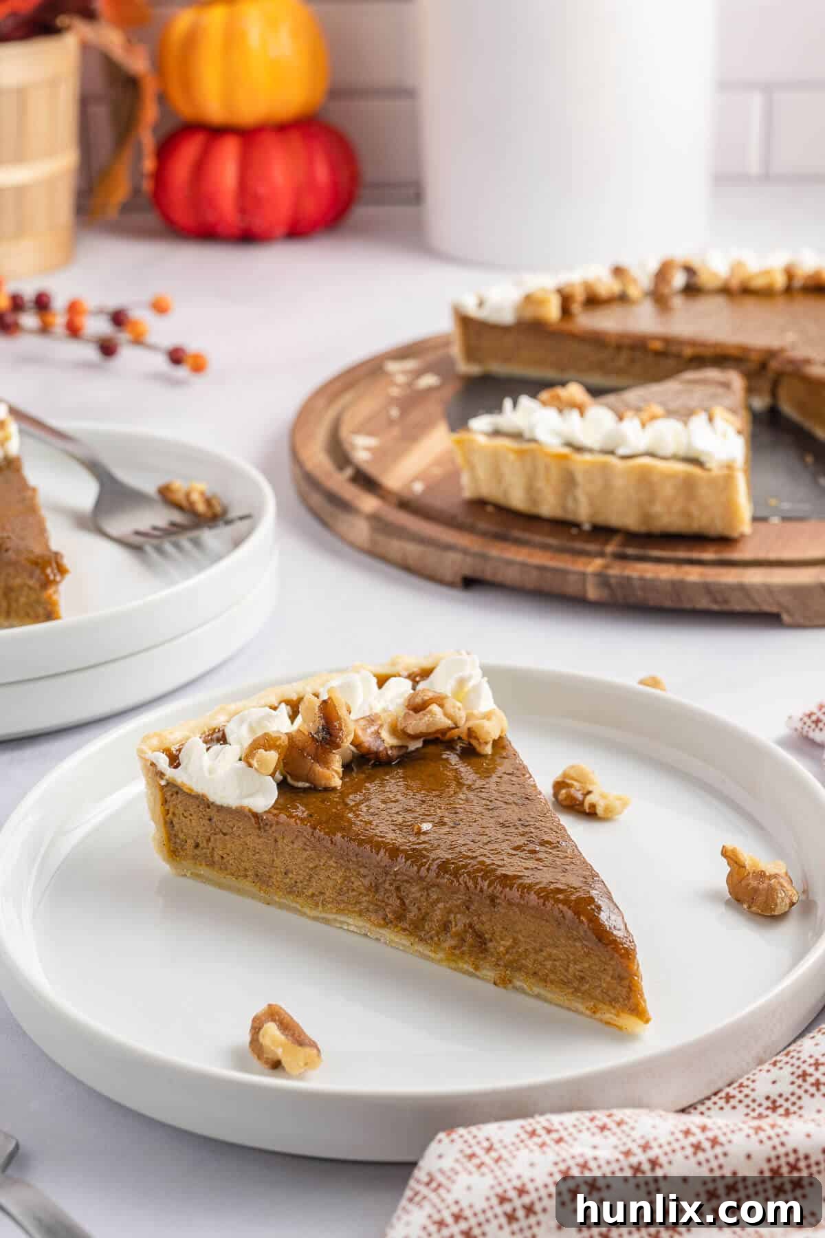 A generous slice of the golden pumpkin tart served on a white plate, showcasing its vibrant color and smooth texture, ready to be enjoyed.