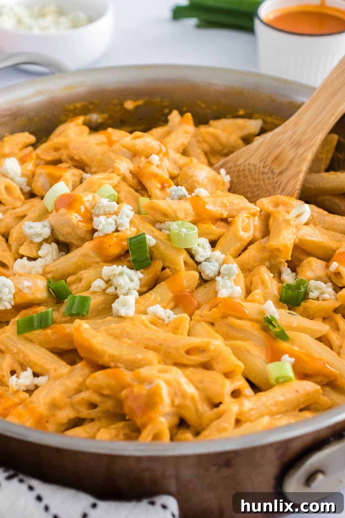 Kickin Buffalo Chicken Pasta 2 Buffalo chicken pasta in a pan with a wooden serving spoon, ready to be served.
