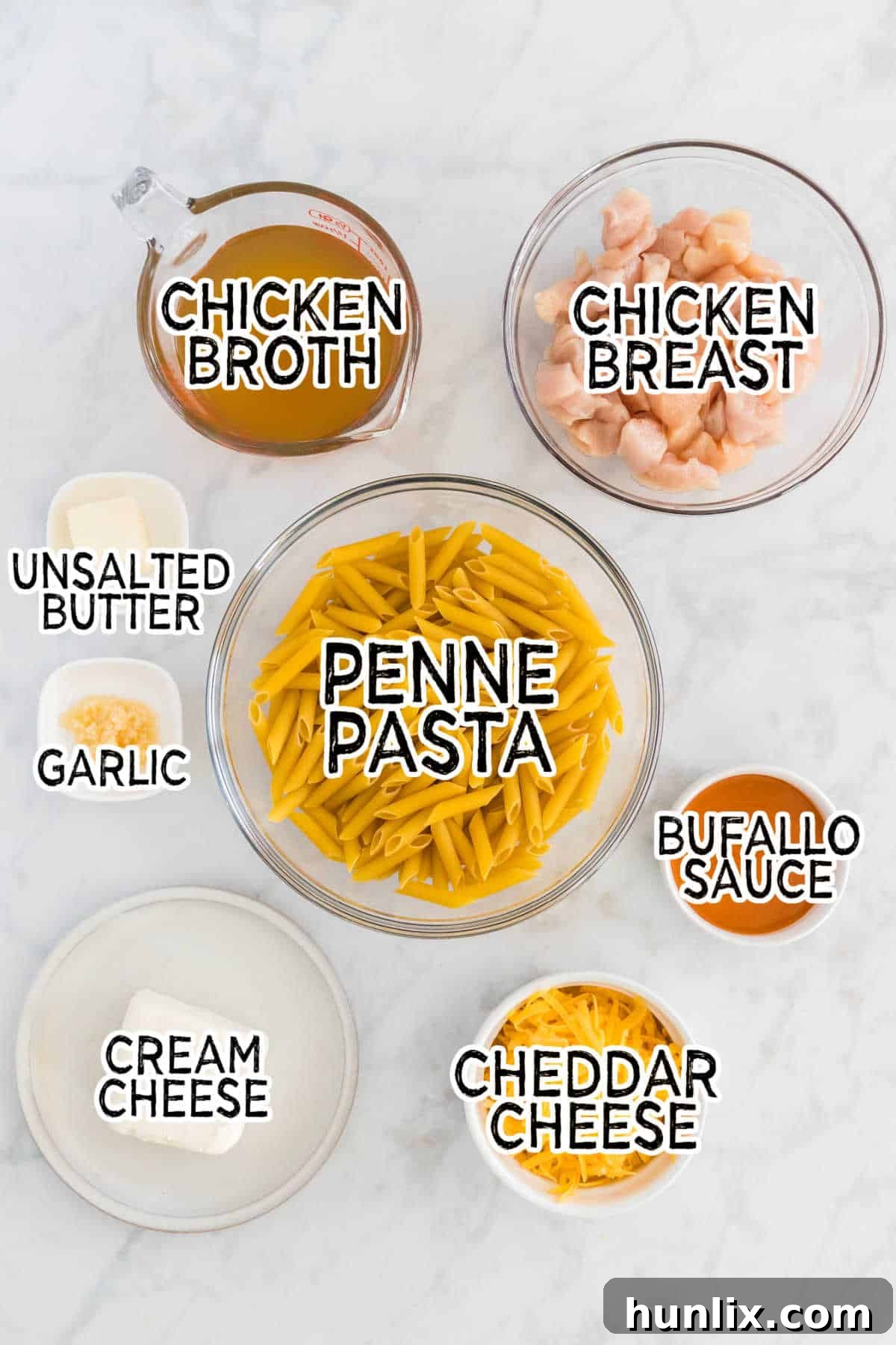 Kickin Buffalo Chicken Pasta 3 Fresh ingredients laid out on a white marble background for making buffalo chicken pasta.