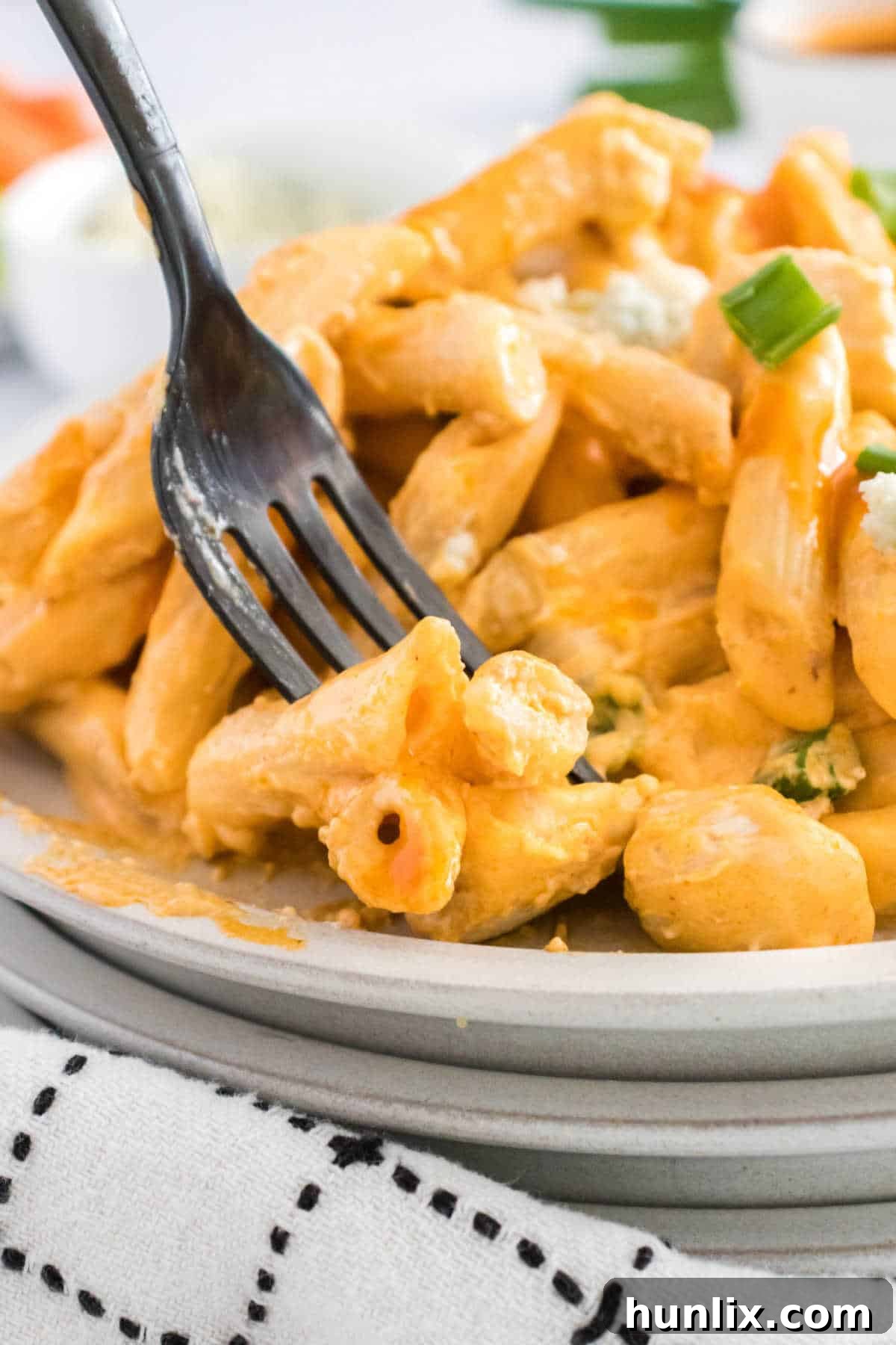 Kickin Buffalo Chicken Pasta 8 The buffalo chicken pasta recipe on a plate with a fork, ready to be eaten.