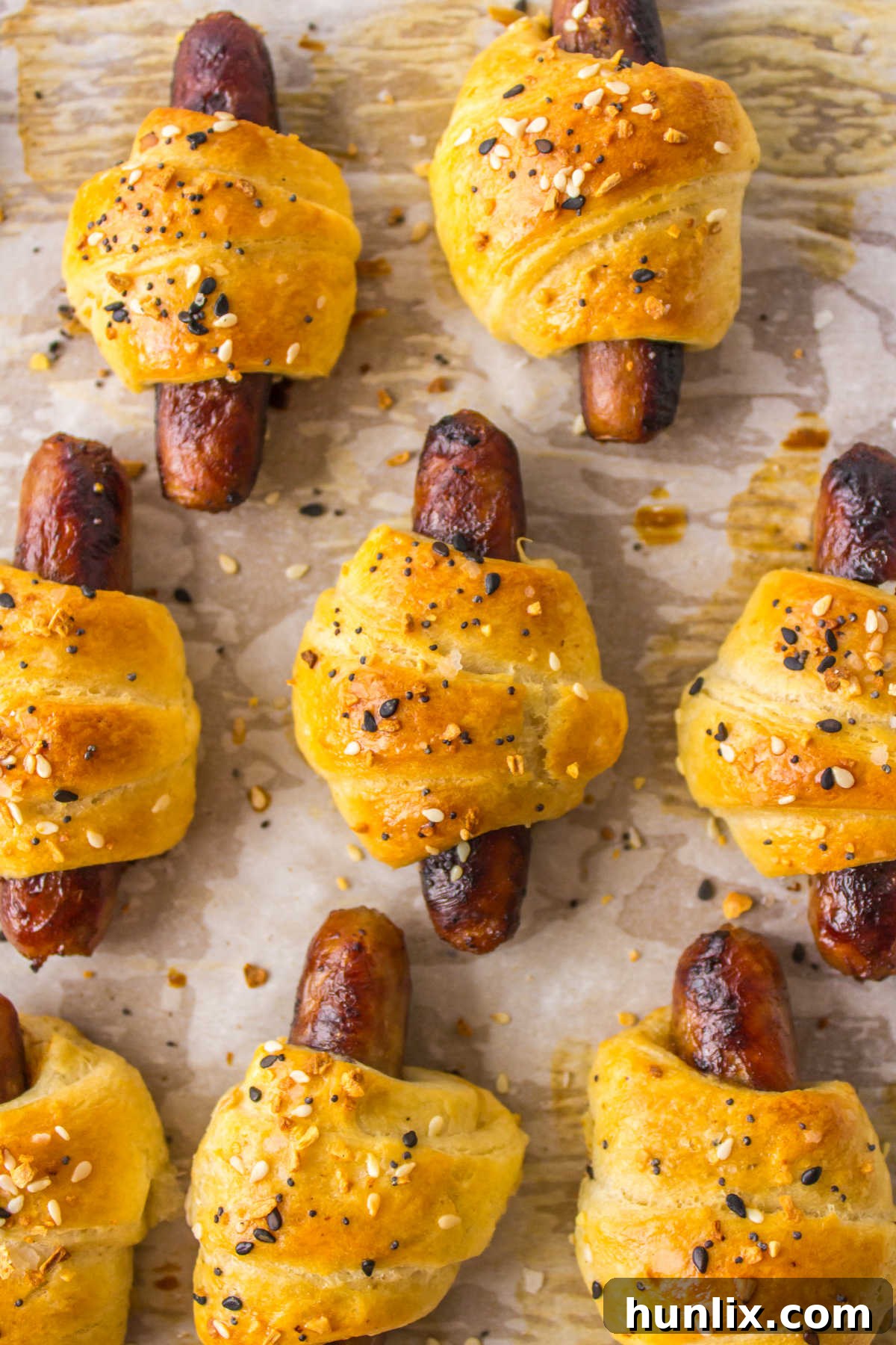 Breakfast pigs in a blanket on a baking sheet, freshly baked and golden.
