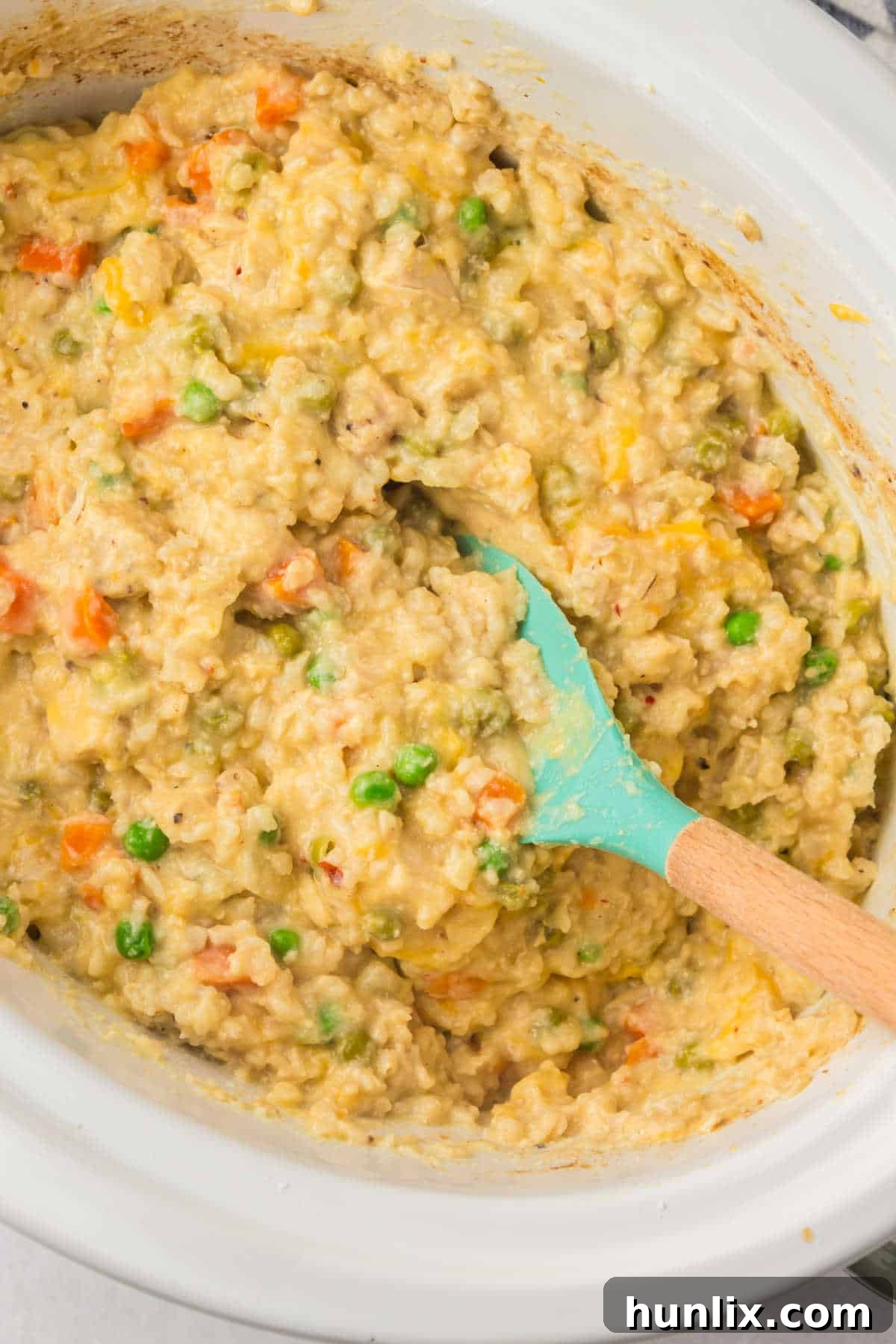 Set-It-and-Forget-It Chicken and Rice 2 Chicken and rice in a crockpot with a spoon, ready to serve.
