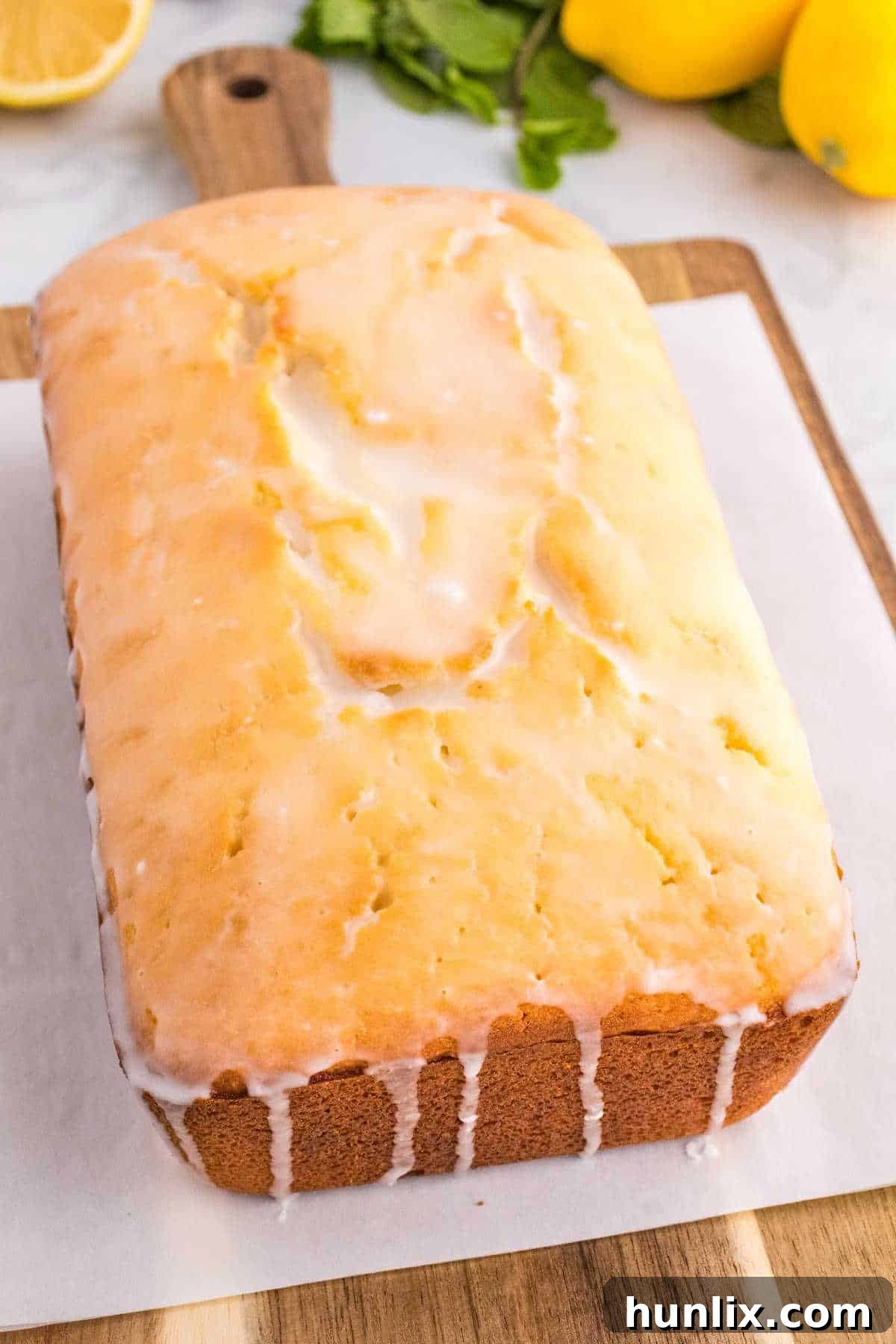 Iced lemon pound cake on a cutting board, ready to be sliced.