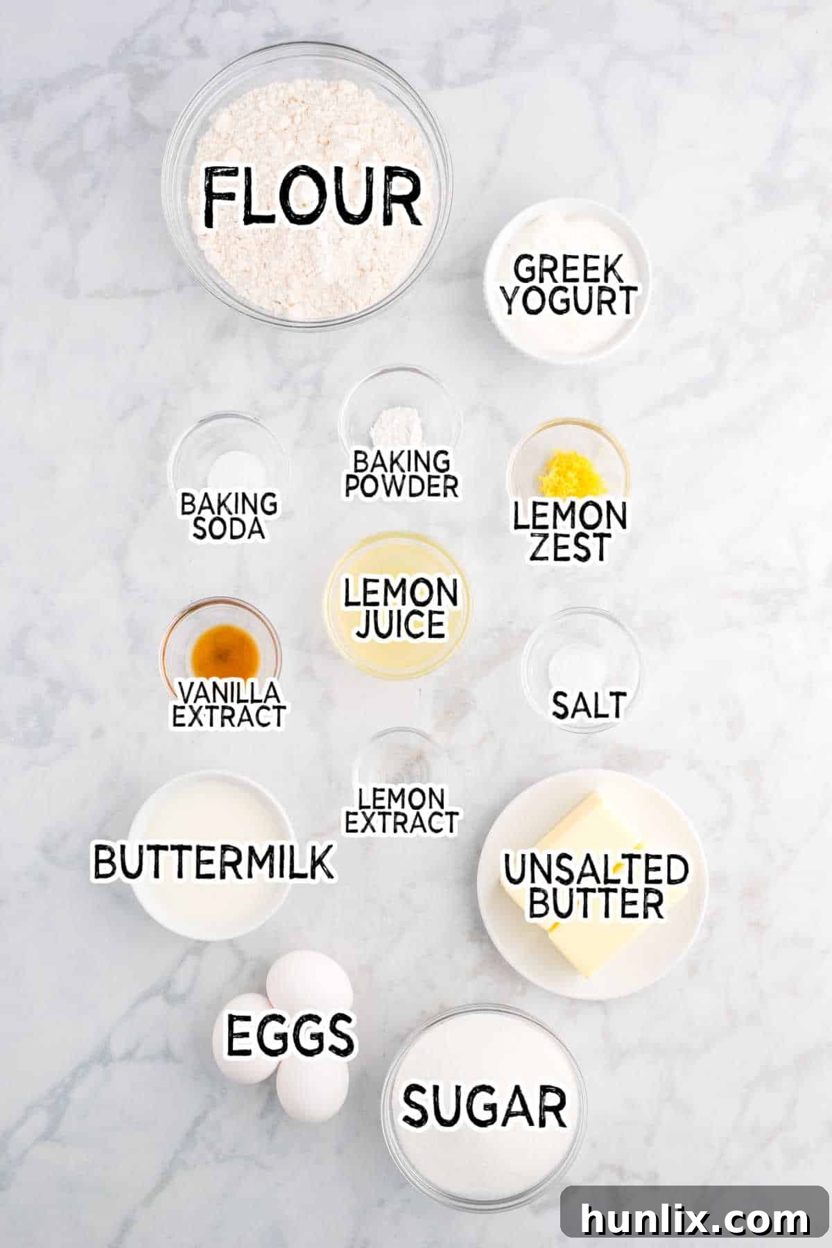 Ingredients for Iced Lemon Pound Cake laid out on a white marble counter.