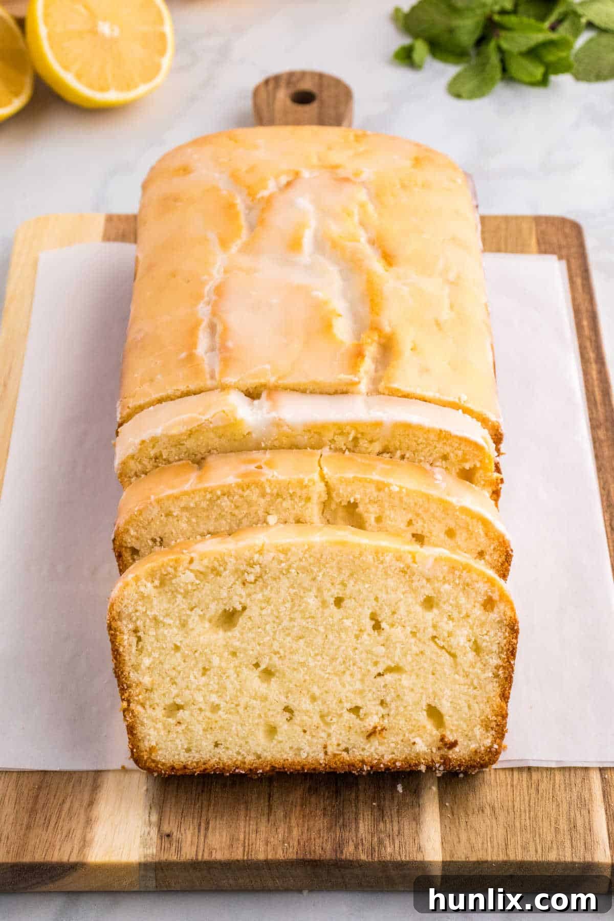 A freshly baked Iced Lemon Pound Cake with several slices cut off, showing the moist interior.