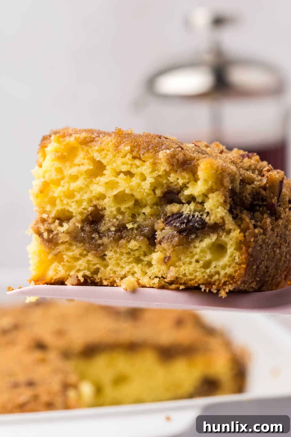 A piece of cake mix coffee cake on a spatula, showcasing its moist texture and streusel topping.