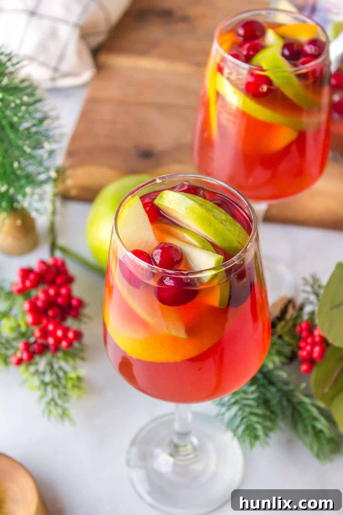 A beautifully presented glass of Holiday Sangria, garnished with fresh fruit.