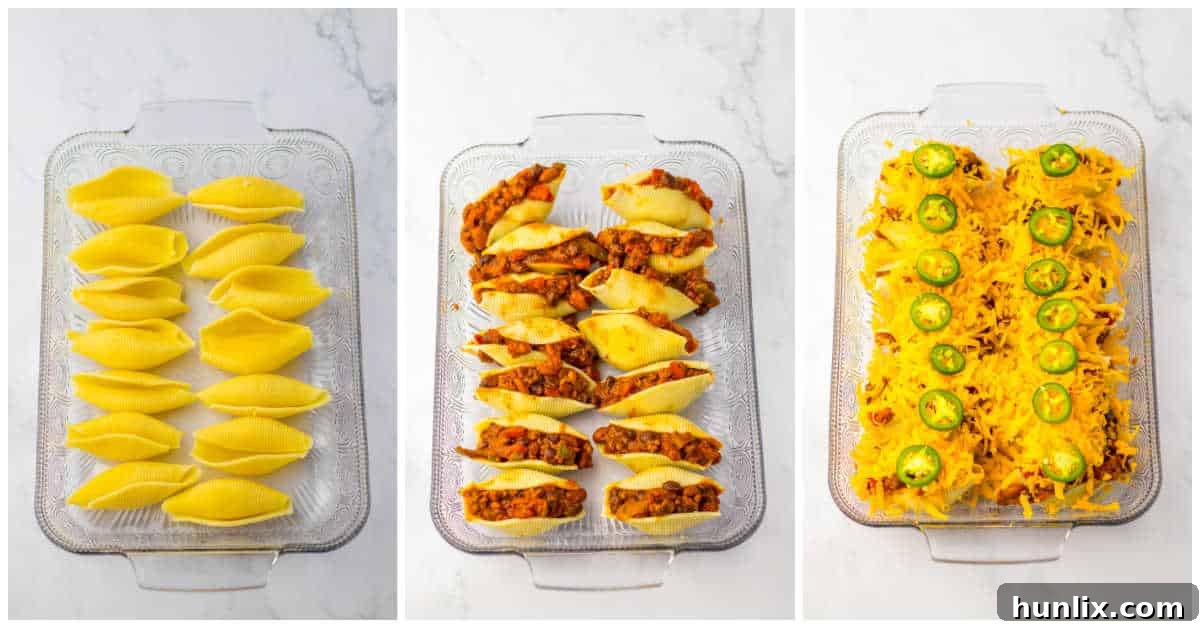 Stuffed pasta shells arranged in a baking dish, topped with chili and shredded cheddar cheese, ready for the oven.