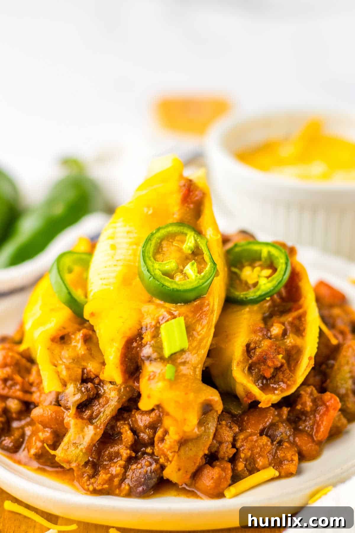 A single portion of chili cheese stuffed shells served on a plate, garnished with fresh cilantro or scallions.