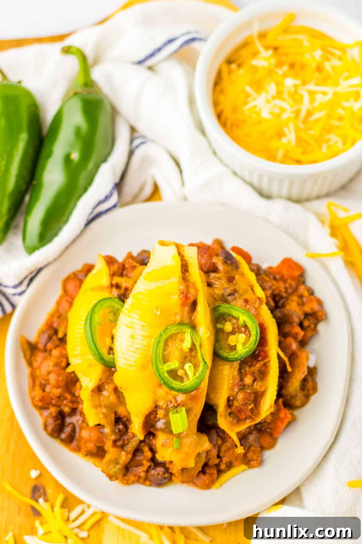 A serving of chili cheese stuffed shells on a plate, garnished with fresh toppings like cilantro and a dollop of sour cream.