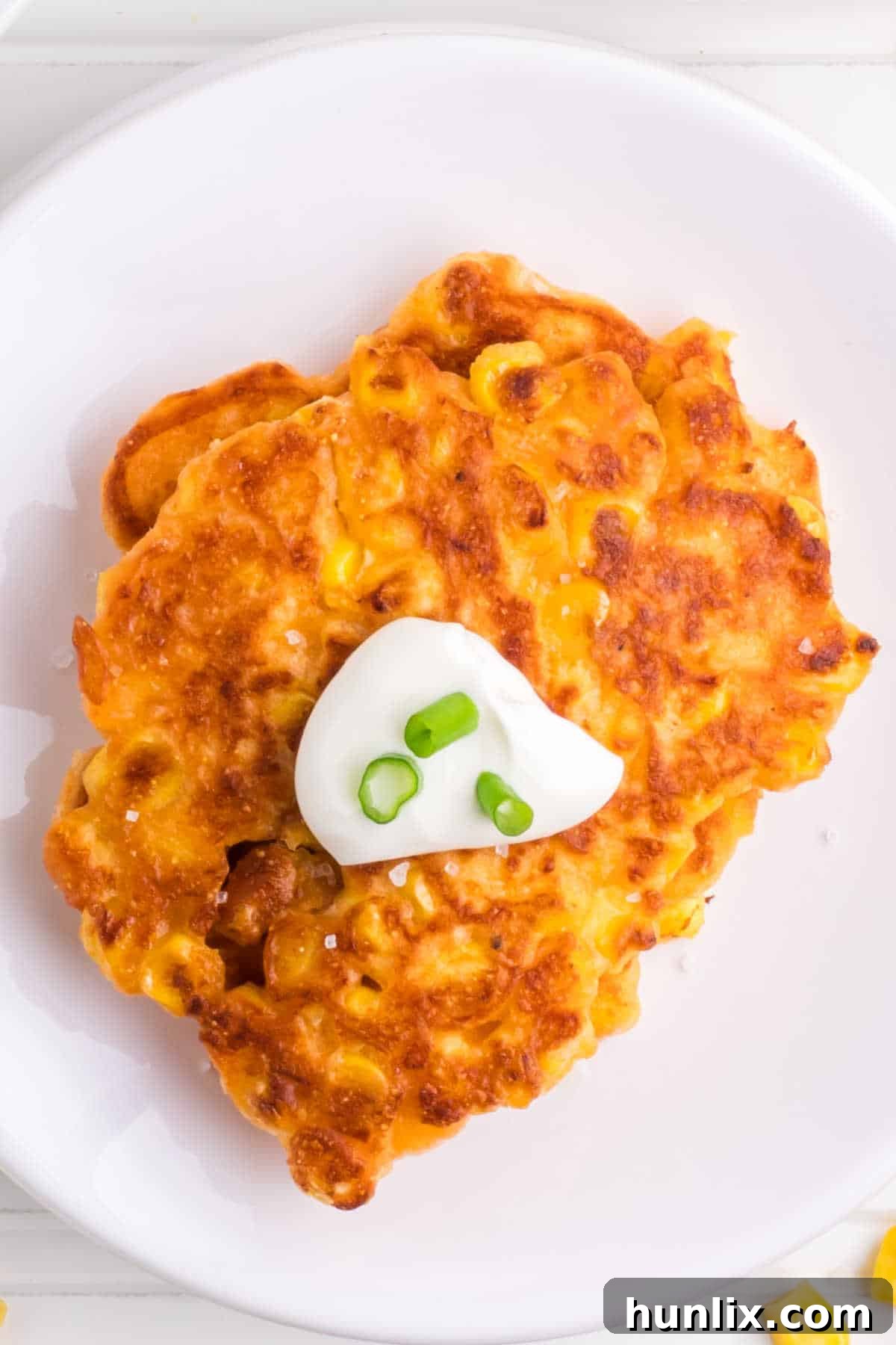 Golden Corn Bites 8 A simple white plate featuring a few perfectly golden and crispy corn fritters, ready to be enjoyed as a snack or a light meal.