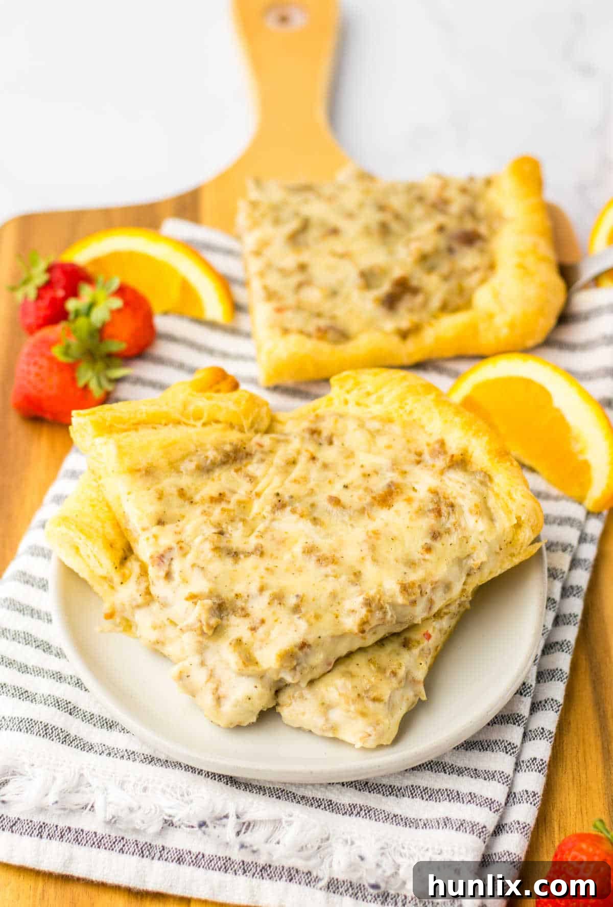 Several appetizing slices of School Breakfast Pizza arranged neatly on a white plate, showcasing the golden crust and creamy topping.
