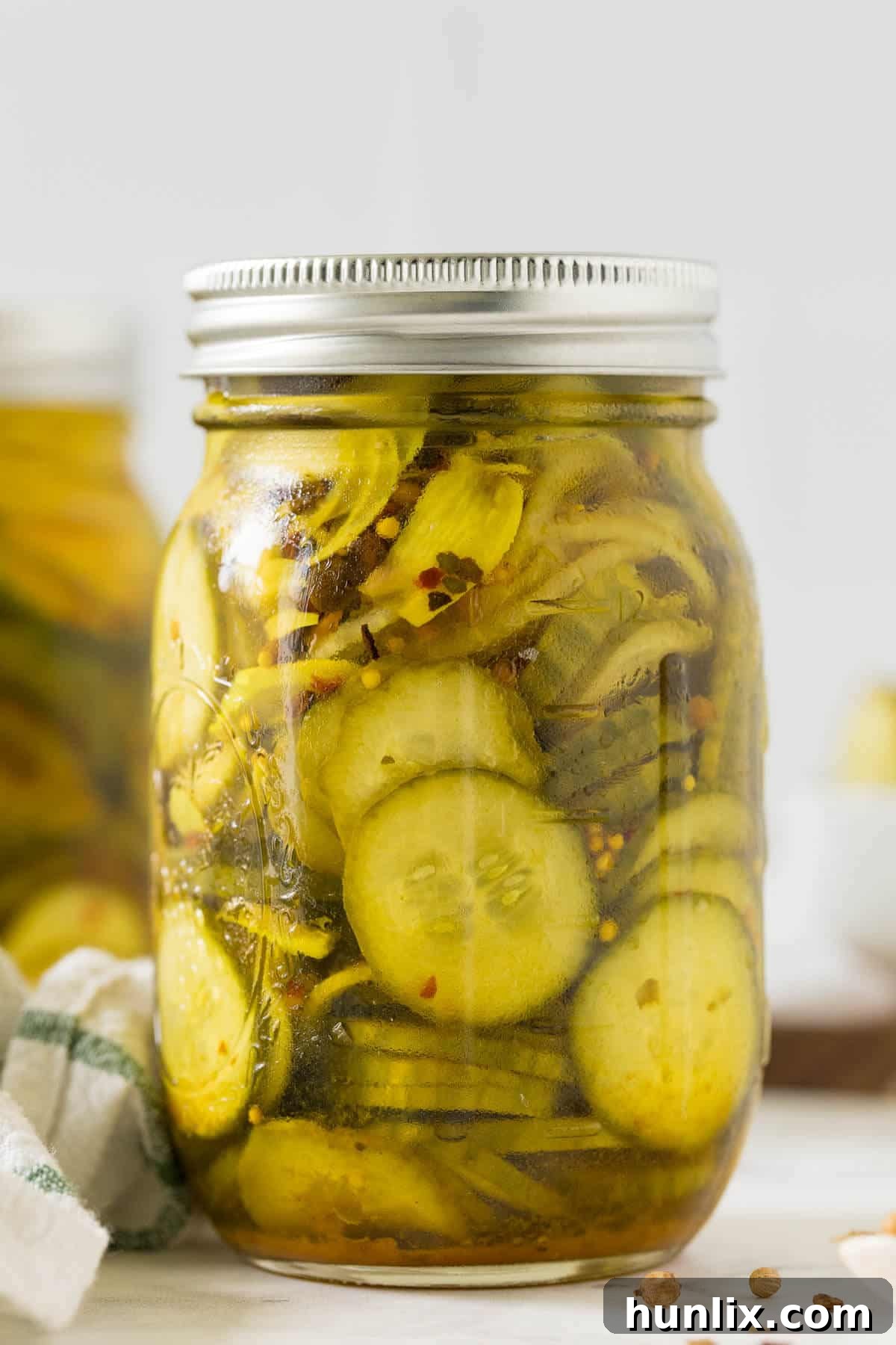 Quick and Easy Refrigerator Bread and Butter Pickles 2 A beautifully arranged jar of homemade refrigerator bread and butter pickles, glistening with brine.