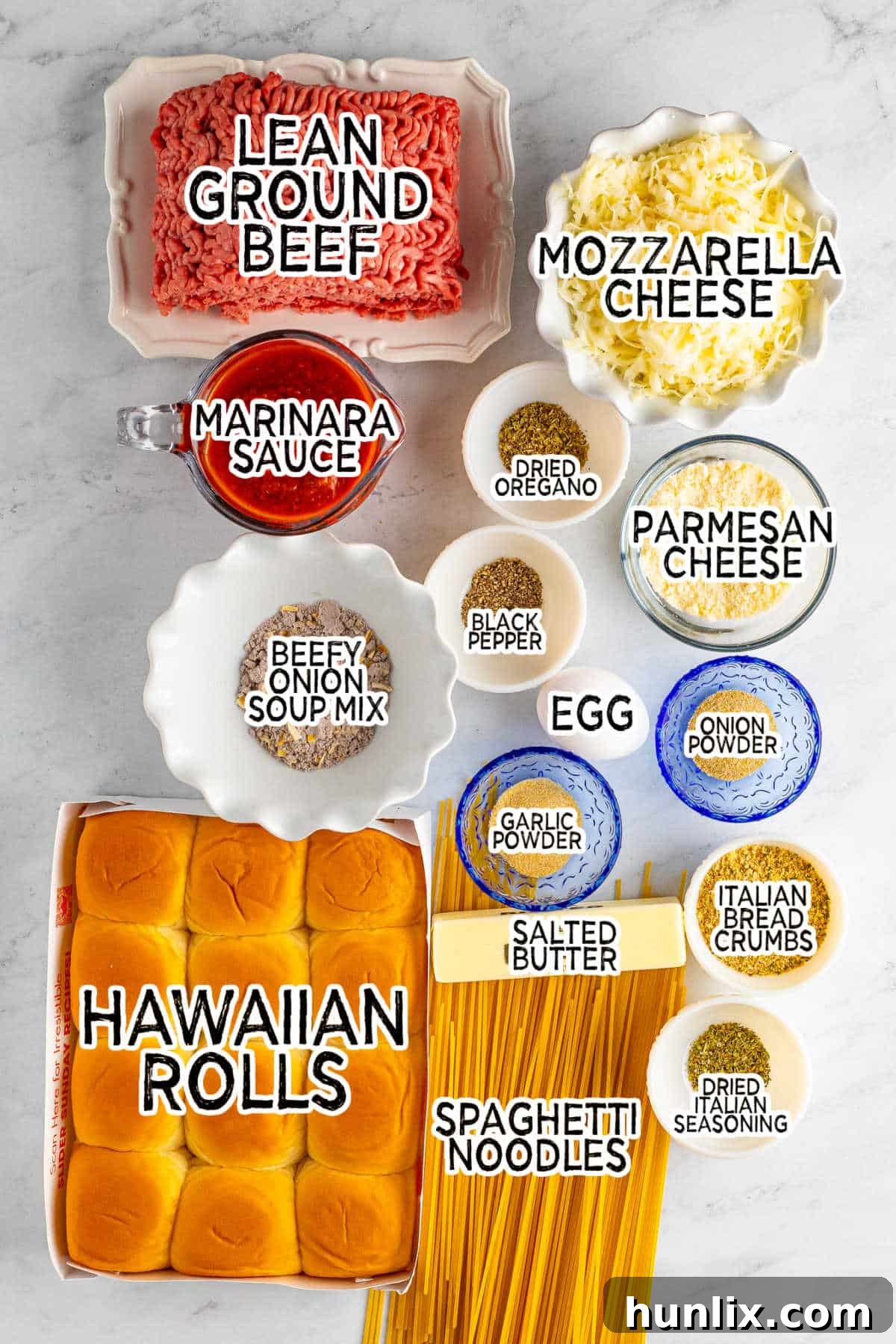 All the fresh ingredients for spaghetti and meatball sliders laid out on a wooden board.