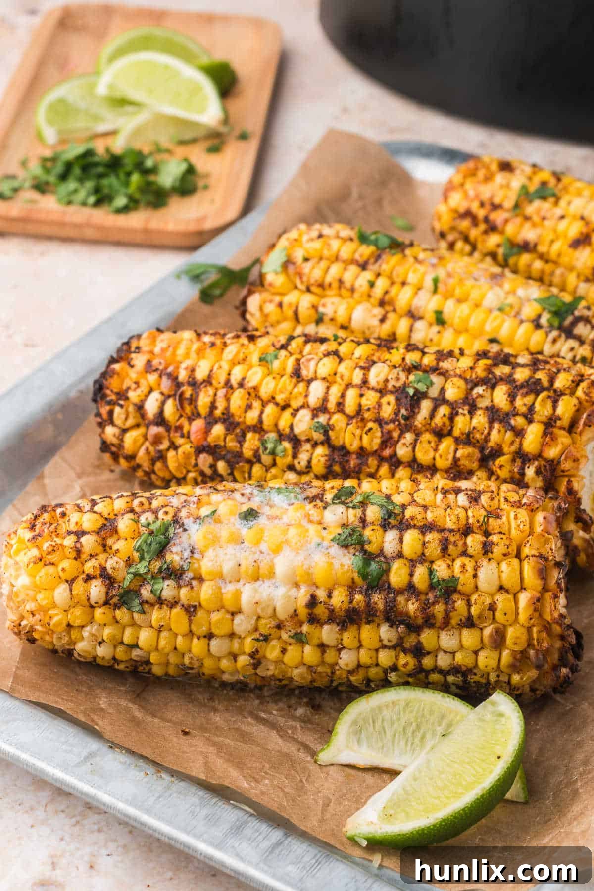 Several air fryer corn on the cob pieces arranged neatly on a white serving platter, ready to be enjoyed.