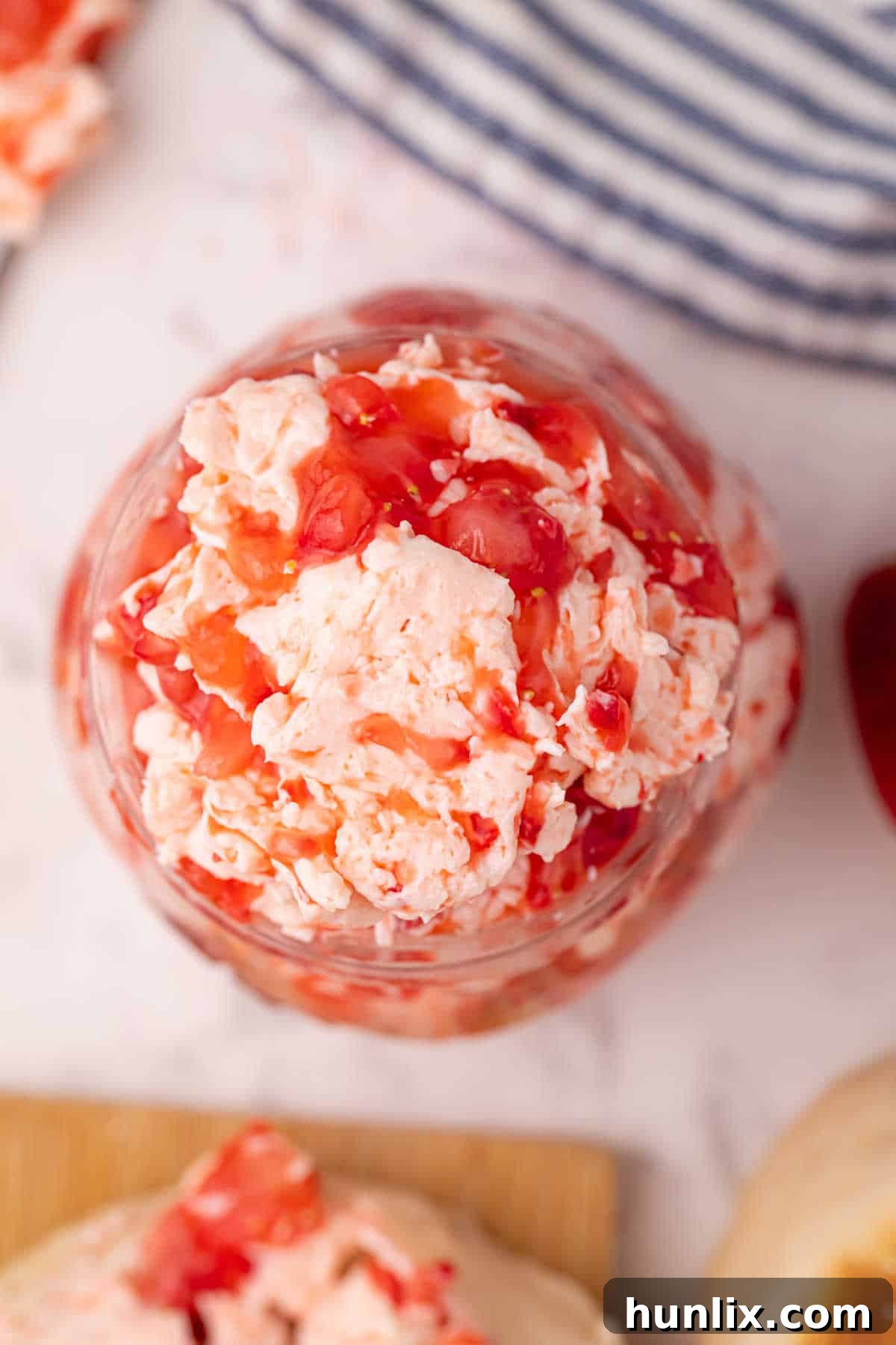 Whipped Strawberry Butter 7 Ahşap bir yüzeyde şirin bir kavanoz çilekli tereyağı, ev yapımı cazibesini vurguluyor.