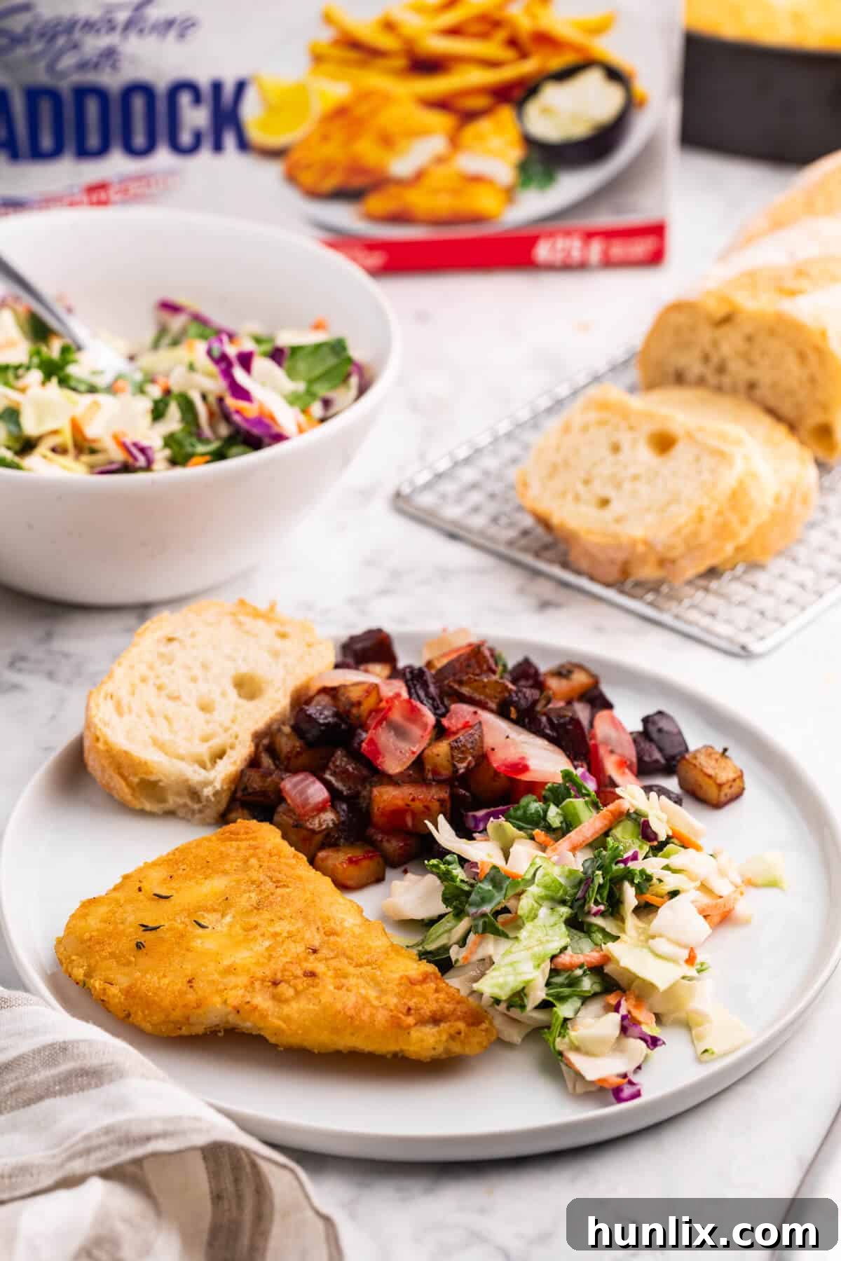 Pan-Seared Fish with Ruby Root Hash 6 A plate of Fish with Beet and Potato Hash served with a fresh green salad and crusty bread, ready to eat.