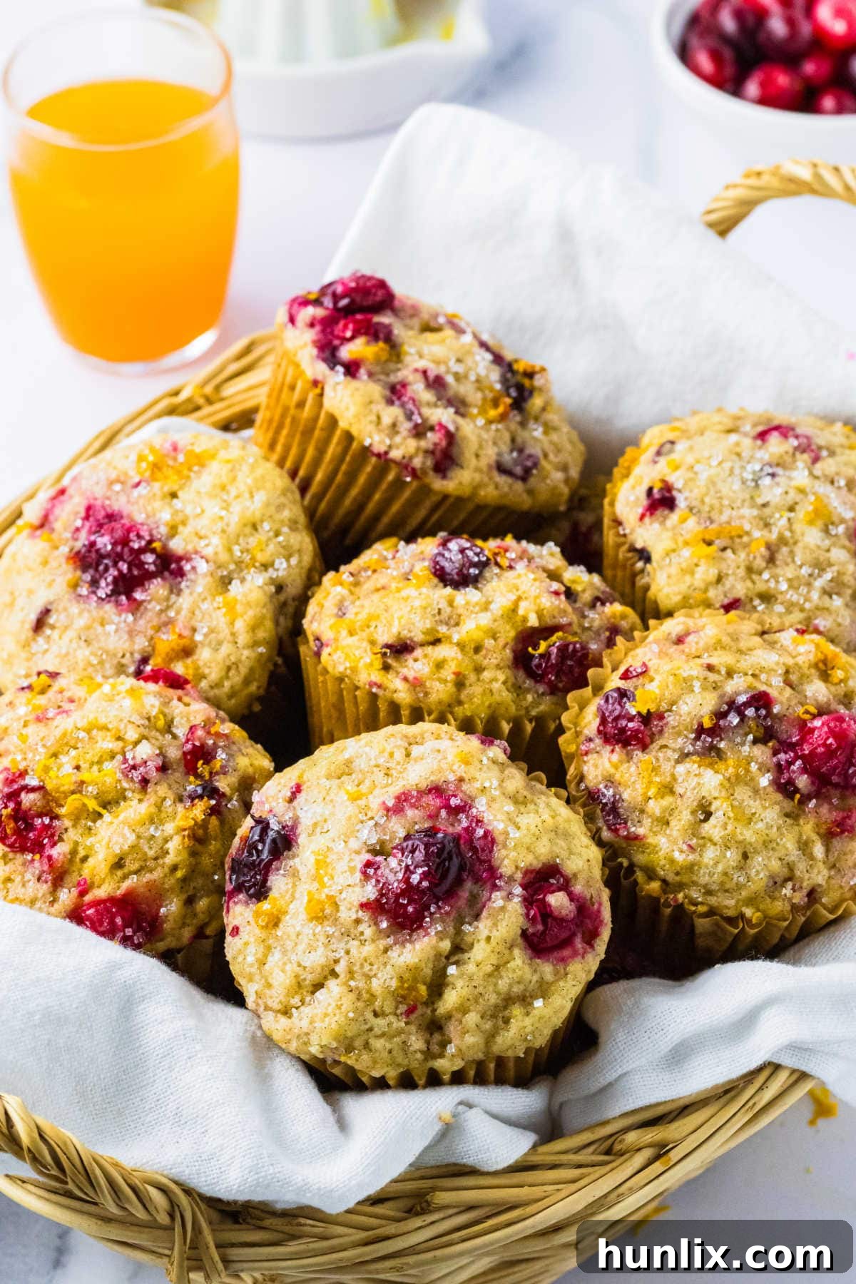 Zesty Cranberry Orange Muffins 7 The cranberry orange muffins in a basket with a white linen.