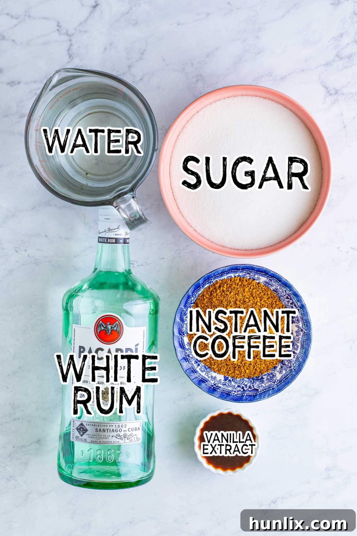 Craft Your Own Coffee Liqueur 3 A collection of the simple ingredients needed for homemade Kahlua laid out on a white marble counter.