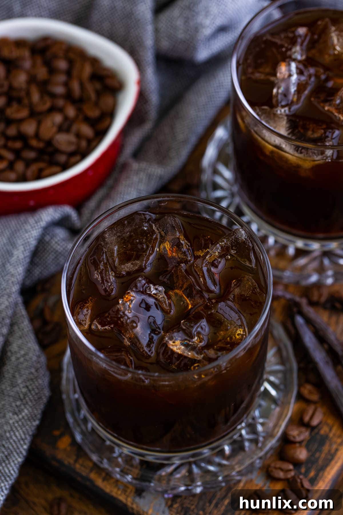 Craft Your Own Coffee Liqueur 7 A beautifully presented glass of homemade Kahlua, ready to be enjoyed on a rustic wooden surface.