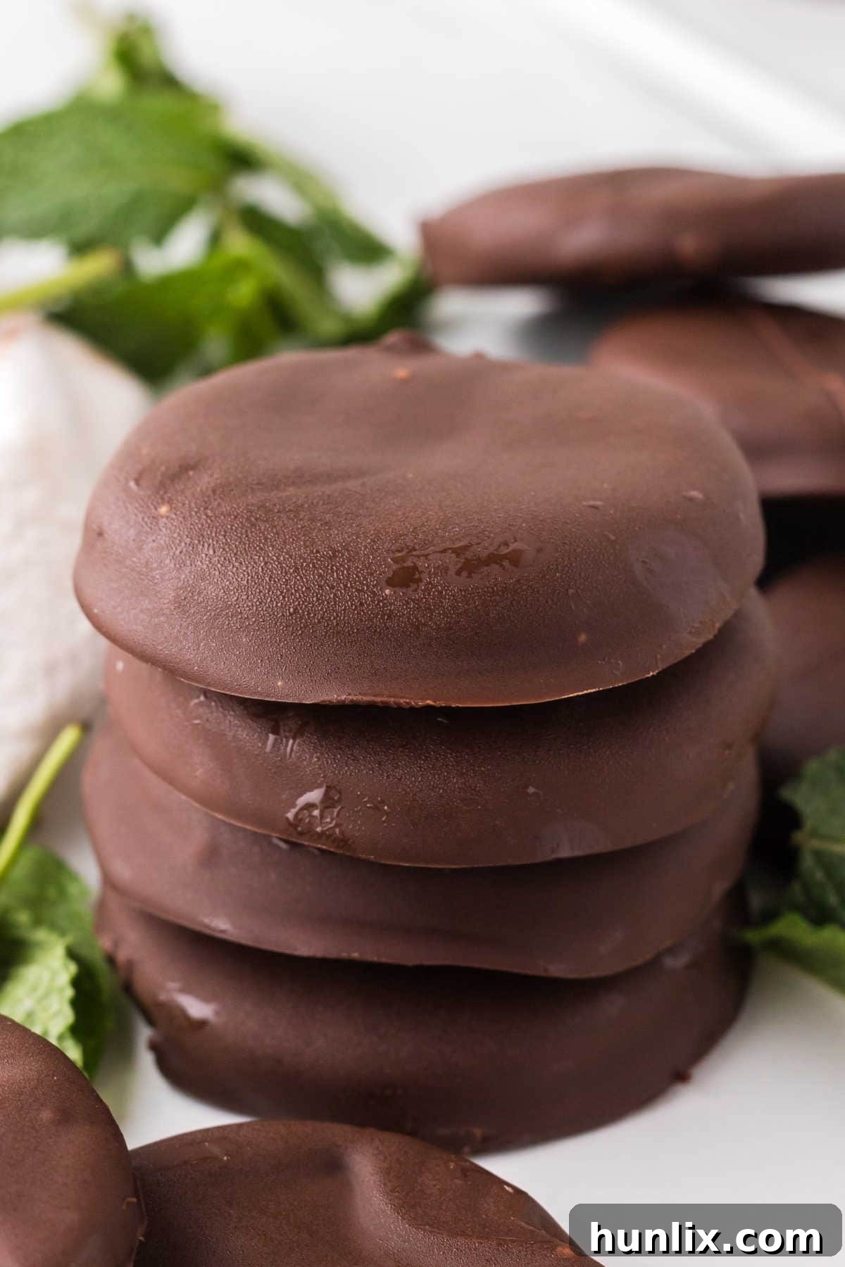Artisan Peppermint Gems 7 A beautifully presented stack of homemade peppermint patties on a small white dessert stand, highlighting their perfect layers and inviting appearance.