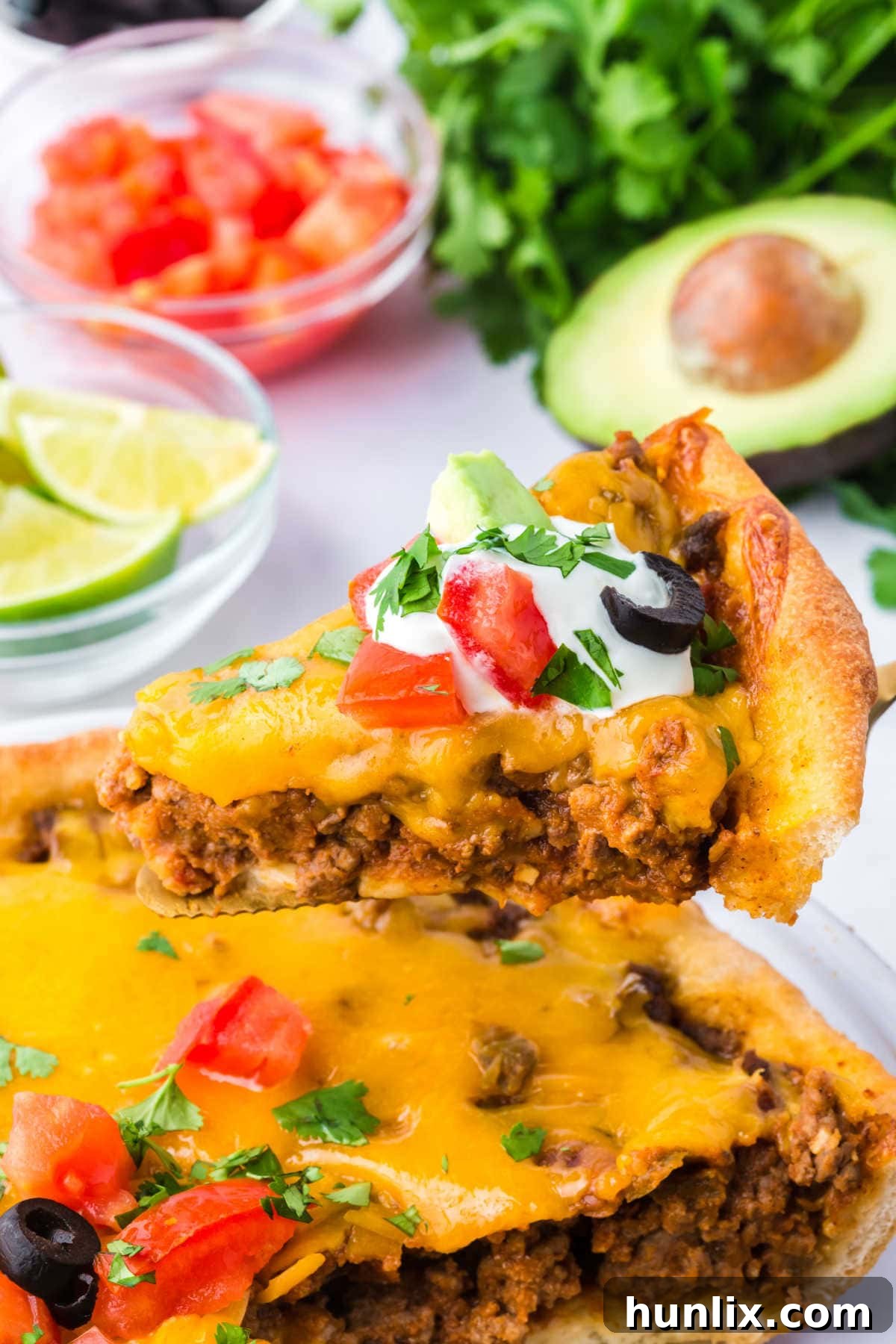 A slice of golden, cheesy Taco Pie being lifted from the dish with a spatula, showcasing its layers.