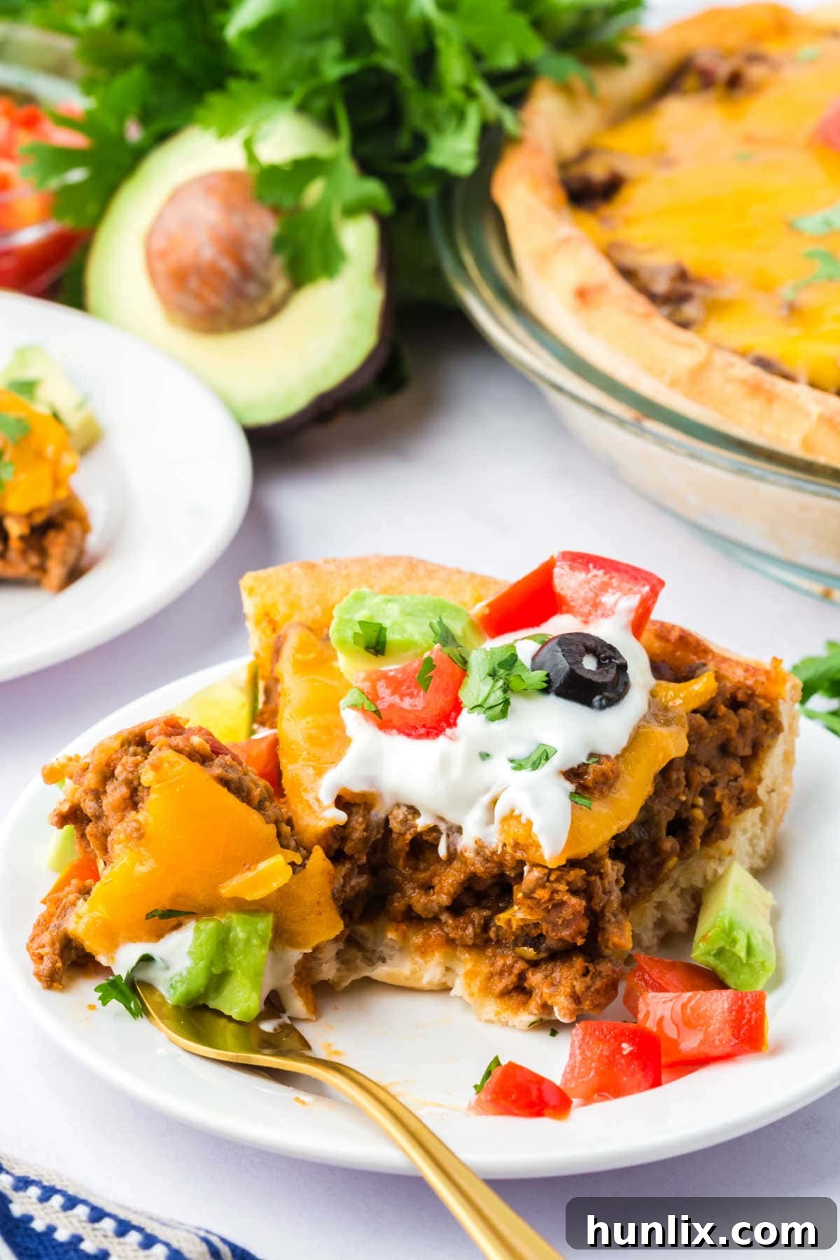 A slice of Taco Pie served on a plate with a fork, ready to be enjoyed, showcasing the rich, cheesy filling and golden crust.
