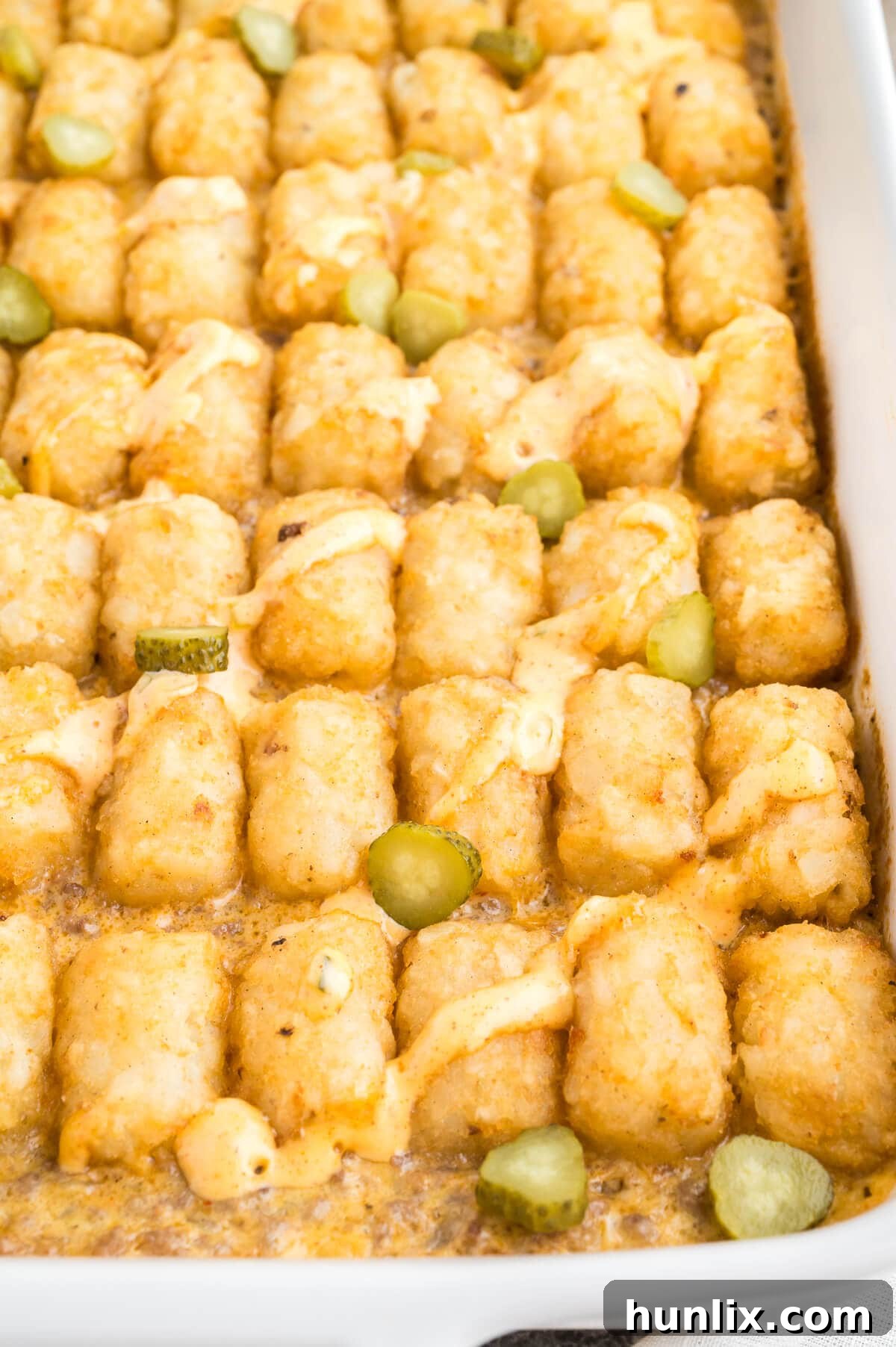 Loaded Big Mac Tater Tot Casserole 2 Big Mac Tater Tot Casserole in a white pan, garnished with lettuce, sesame seeds, and Big Mac sauce.