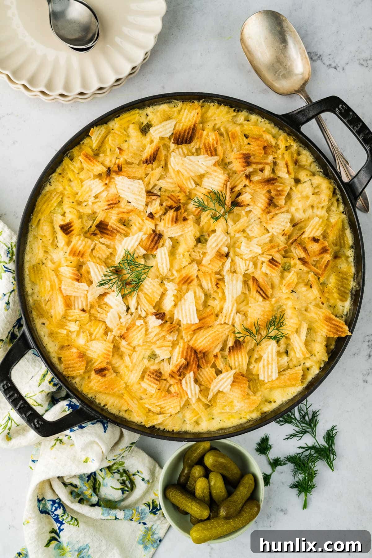 Dill-ightful Macaroni Bake 2 A skillet filled with golden-brown Dill Pickle Mac and Cheese, topped with crispy chips.