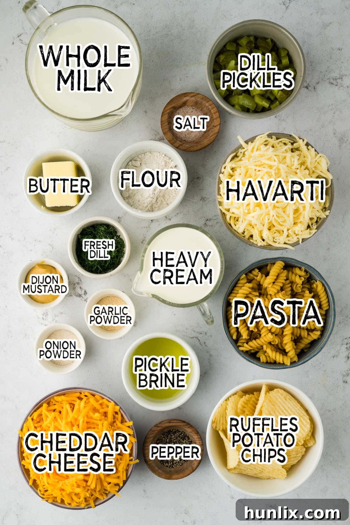 Dill-ightful Macaroni Bake 3 Various ingredients for Dill Pickle Mac and Cheese arranged on a grey background.