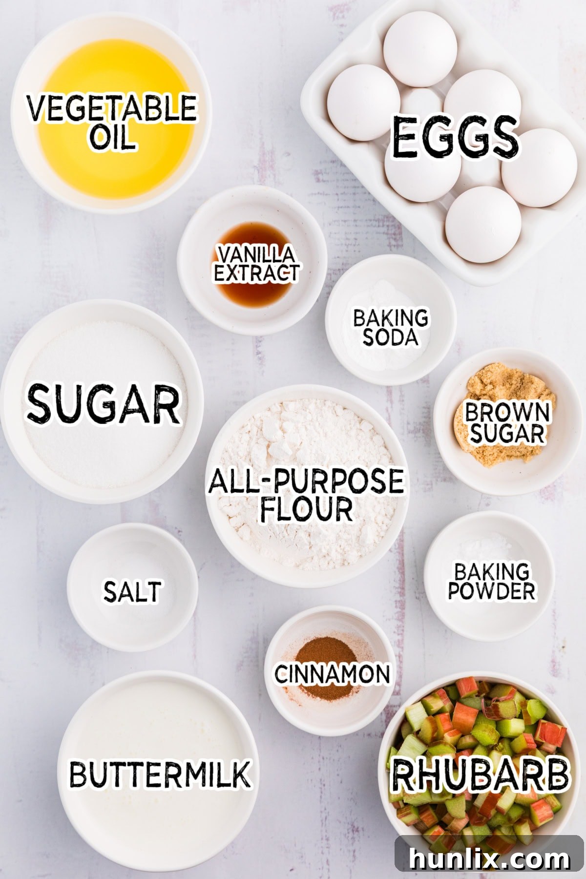 A collection of fresh rhubarb muffin ingredients laid out on a white background.
